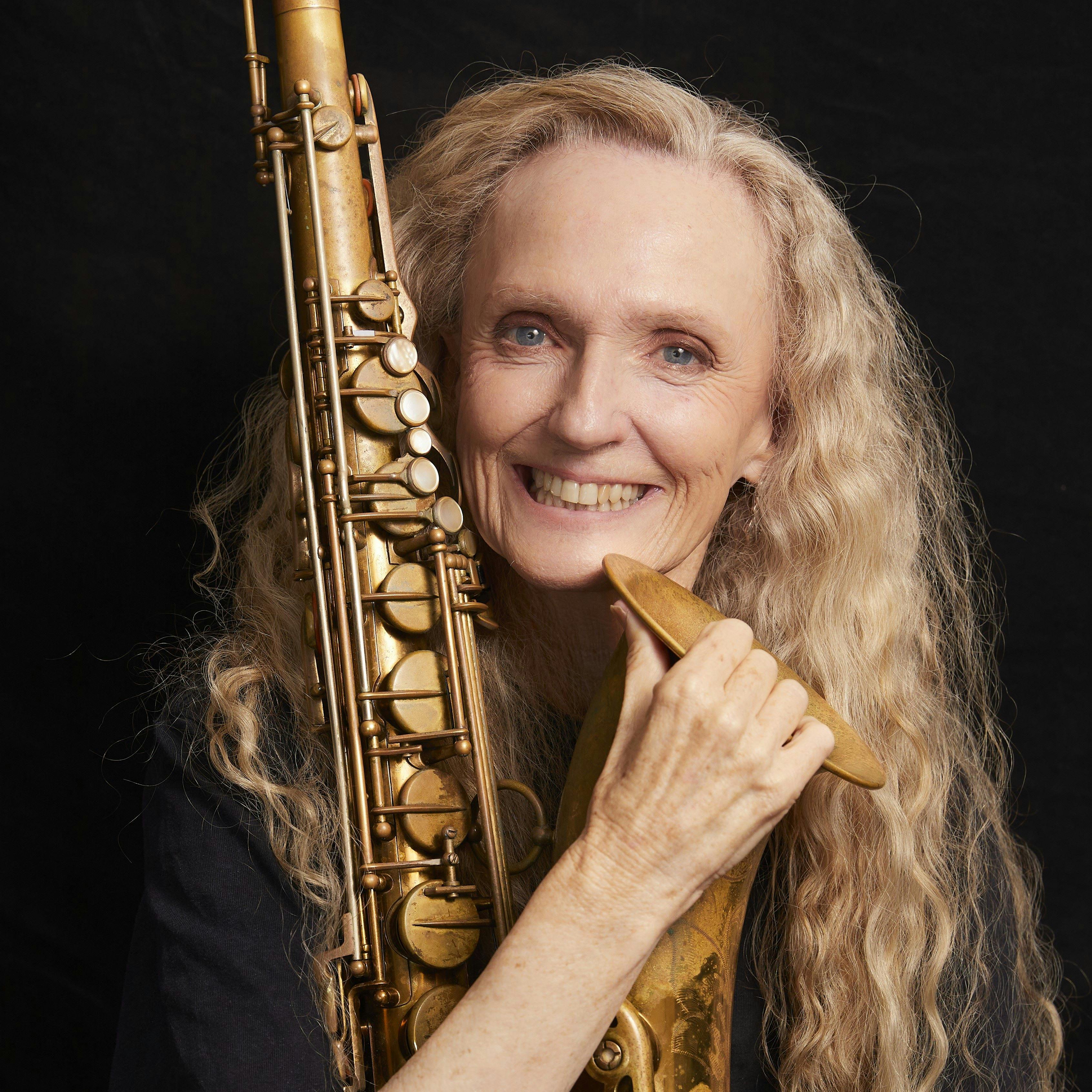 Photo of Sandy Evans with saxophone on a black background