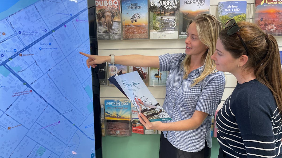 Photo of staff member assisting a guest with a touchscreen map Photo of staff member assisting a guest with a touchscreen map