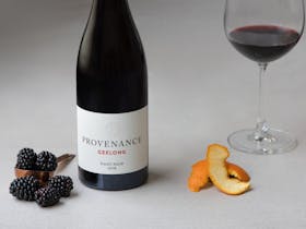 A bottle of Pinot Noir with fresh berries alongside.