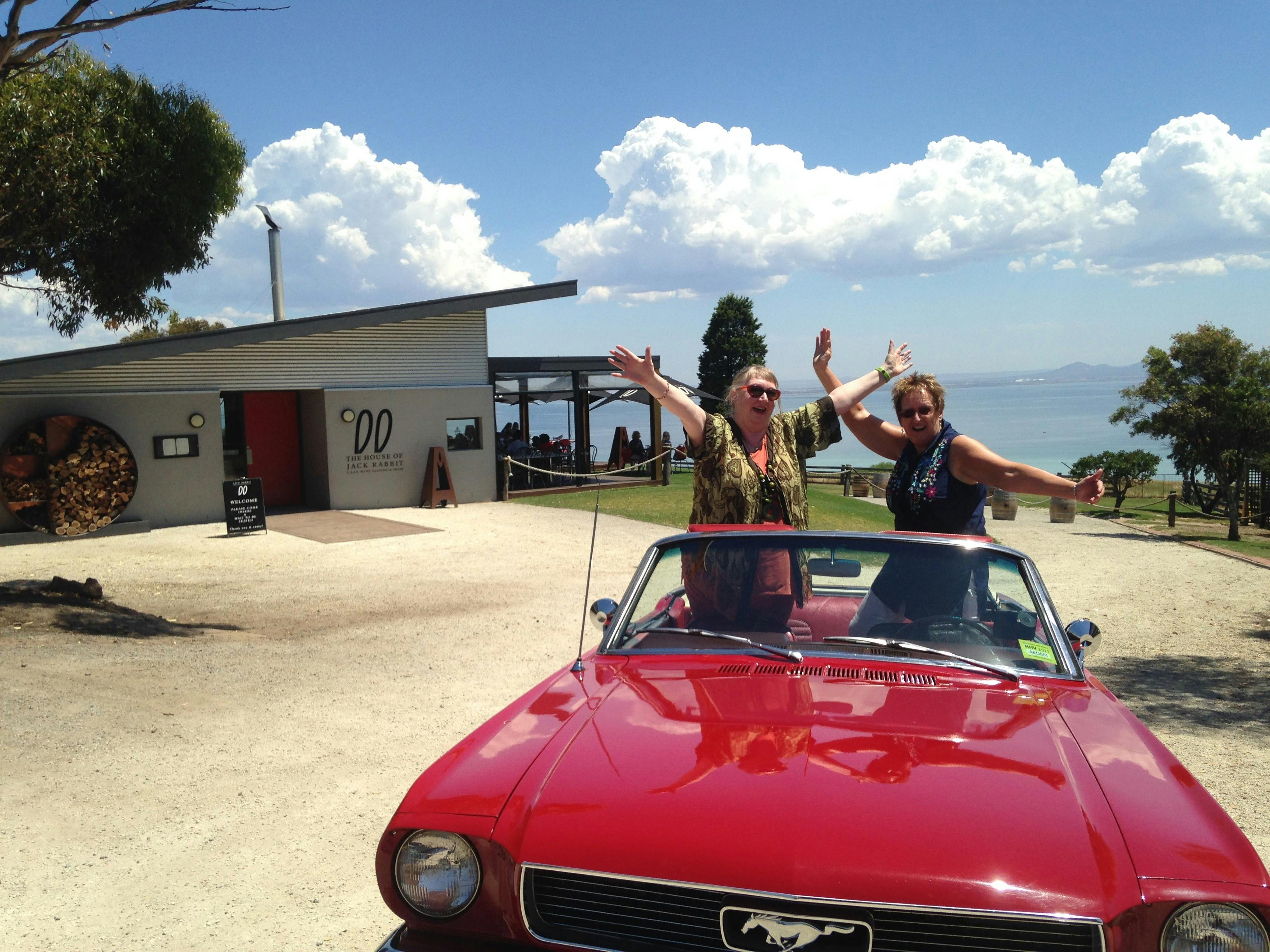 Two women in the back of the Mustang Convertible on a winery tour of Bellarine taken at Jack Rabbit.