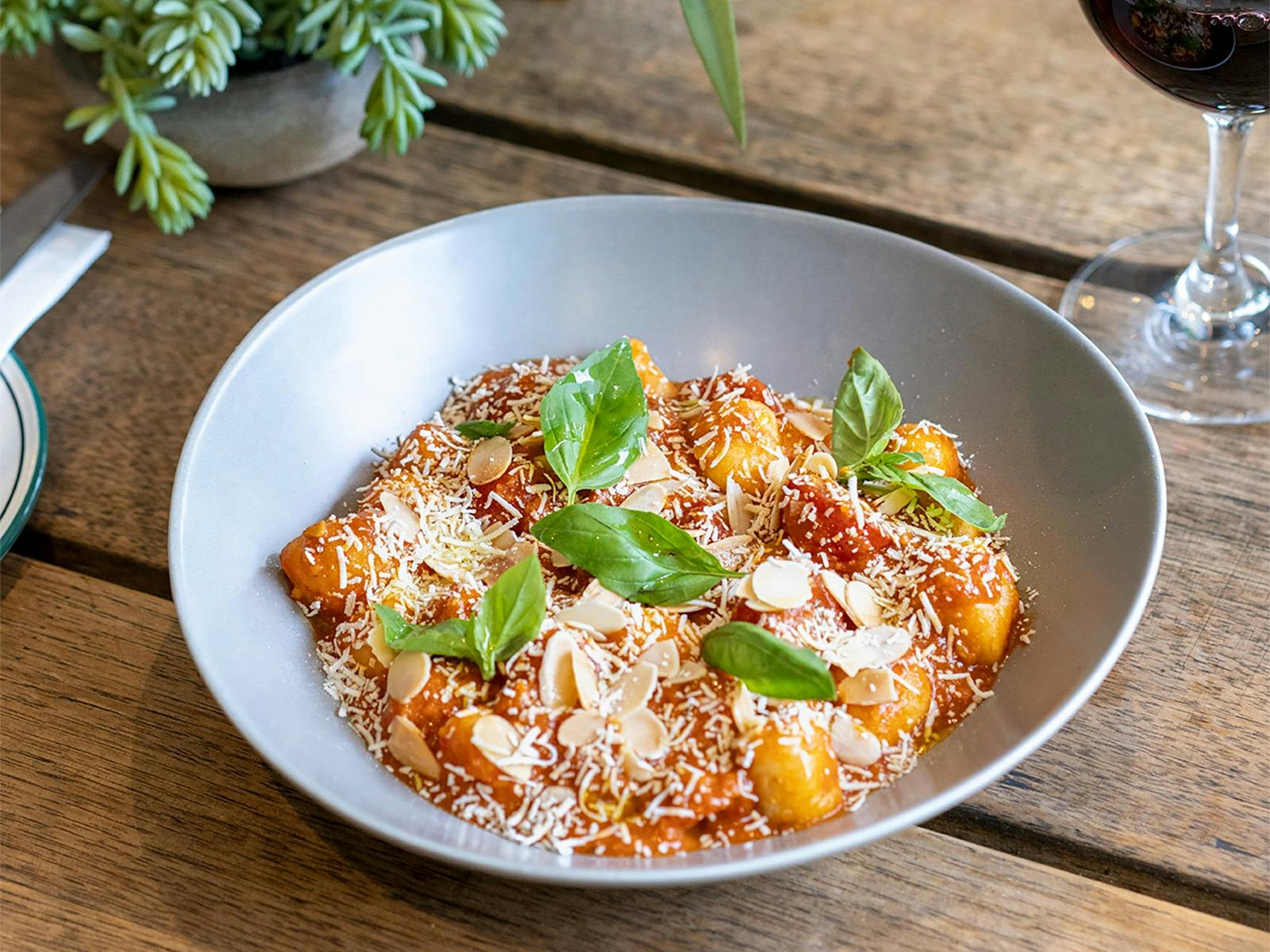 Gnocchi Alla Trapanese with tomato almond pesto, cherry tomatoes, salted ricotta, and basil