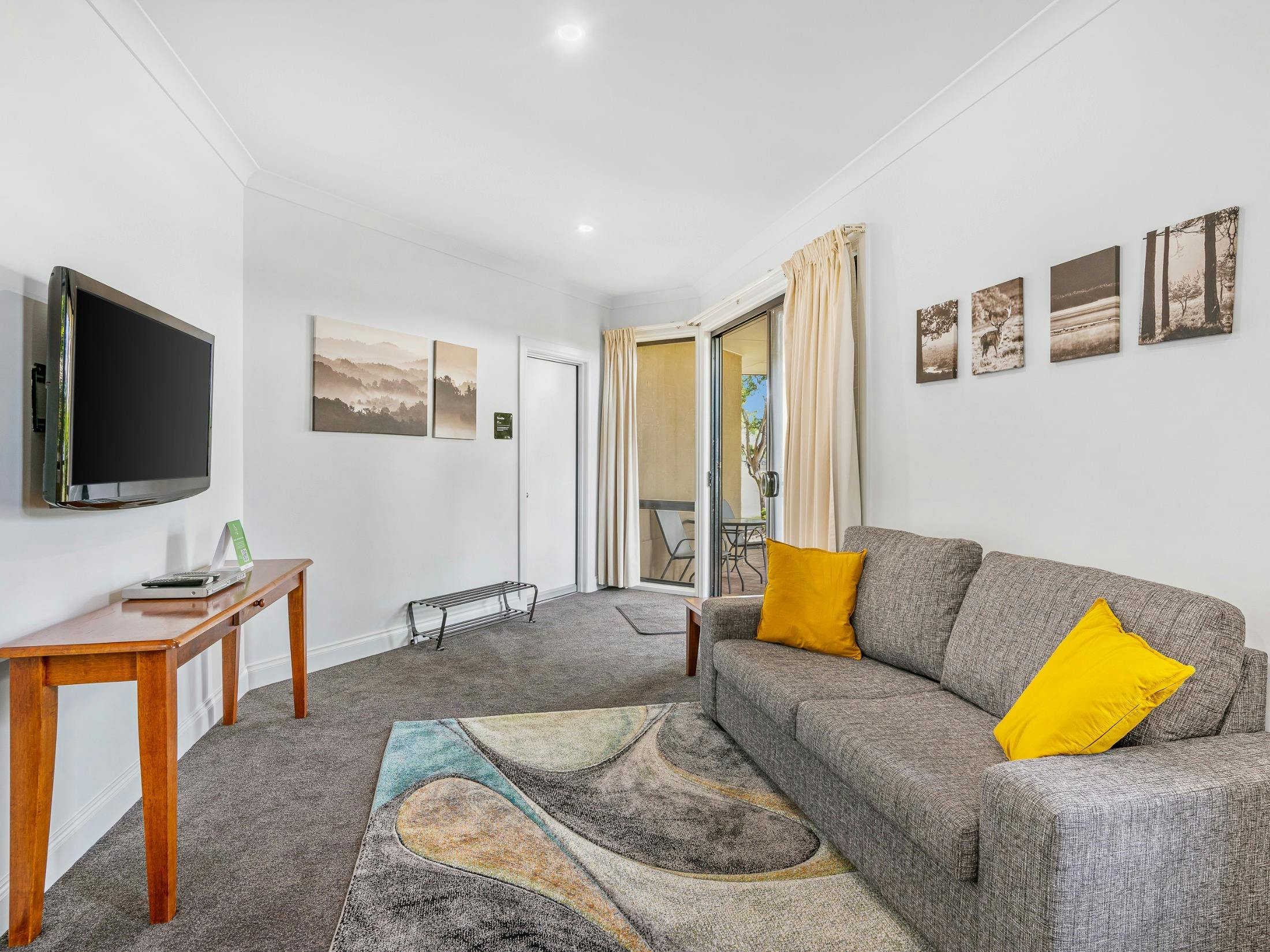 Living room with sofa, TV and sliding doors to outdoor patio