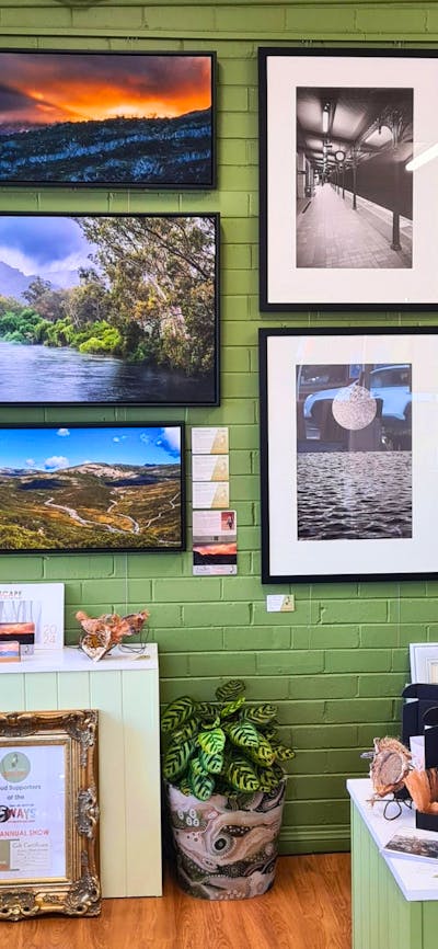 Photographs and oil colour paintings hung on a wall