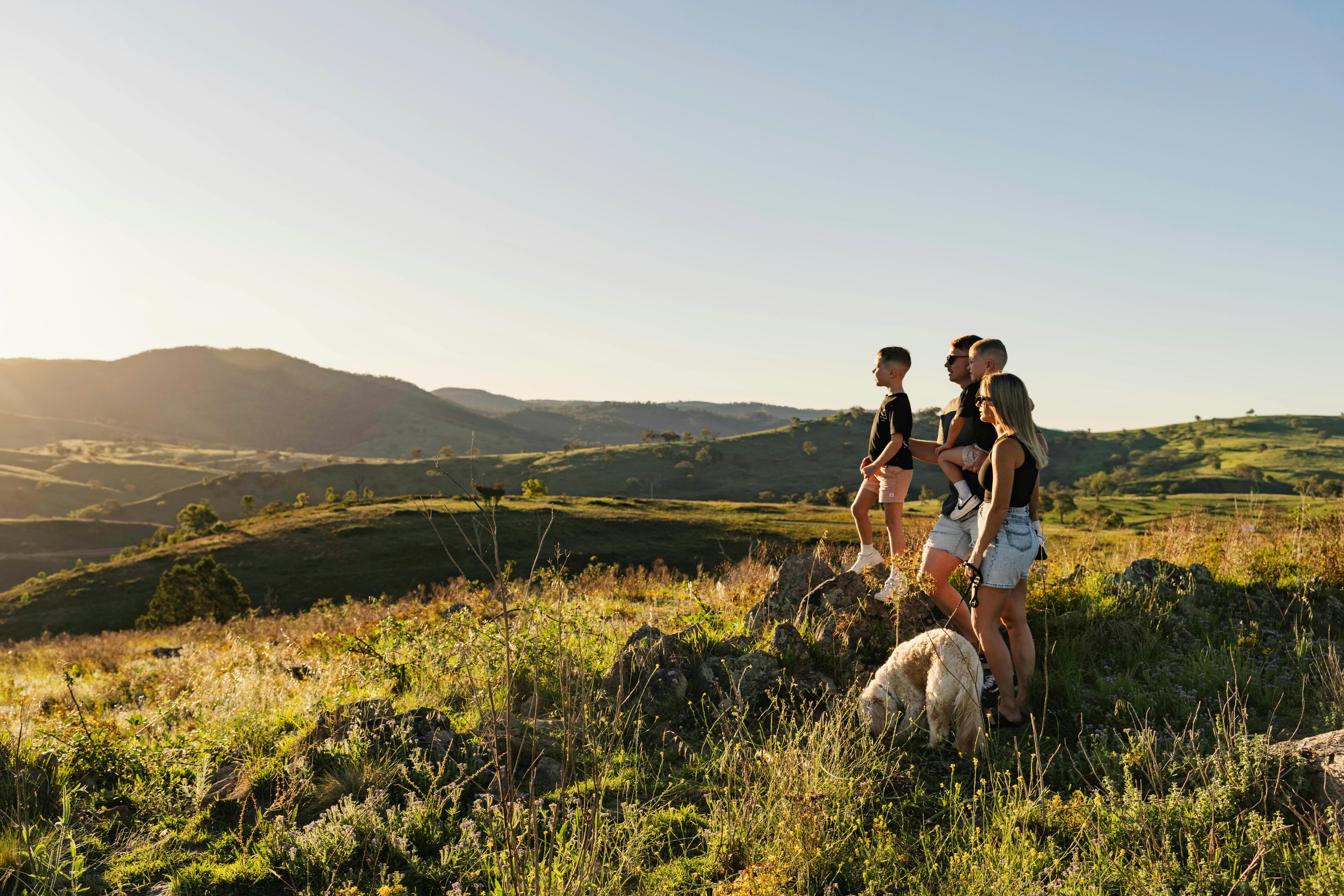 A family stands ontop of a hill overlooking the Bridle Track