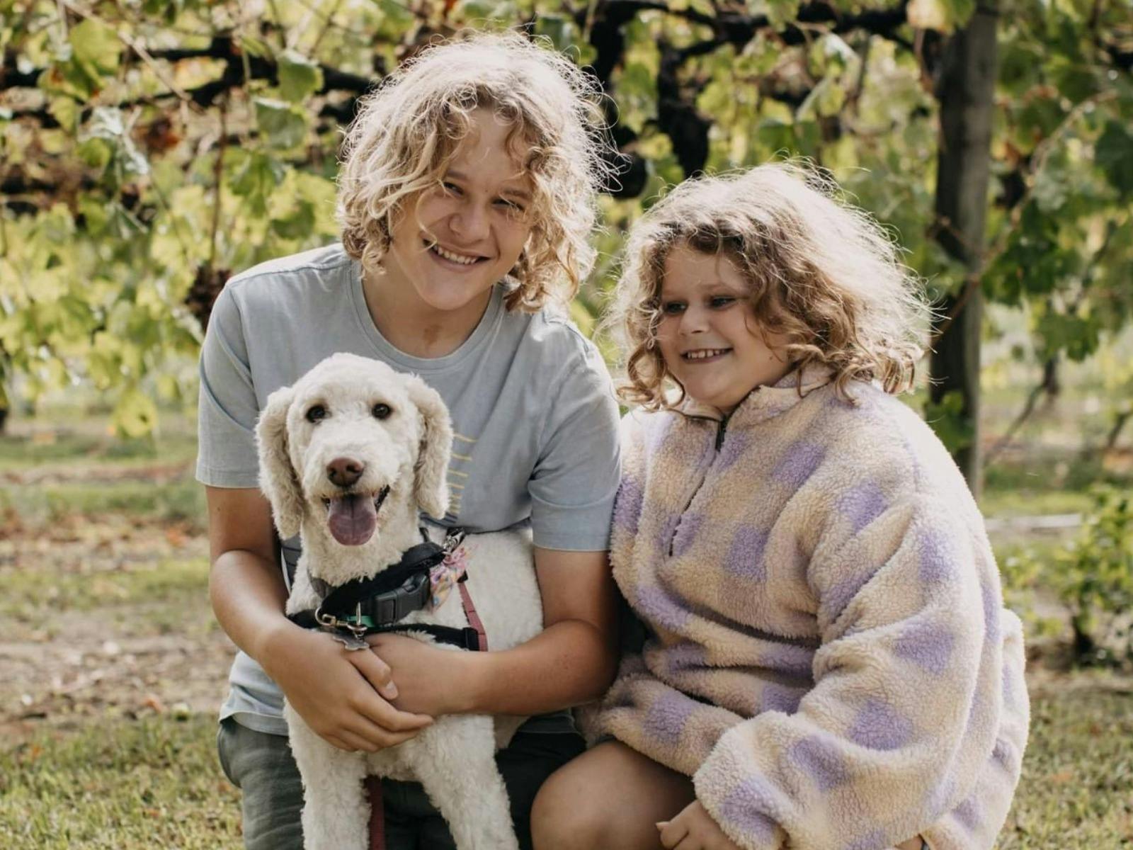 2 kids and a dog at a vineyard
