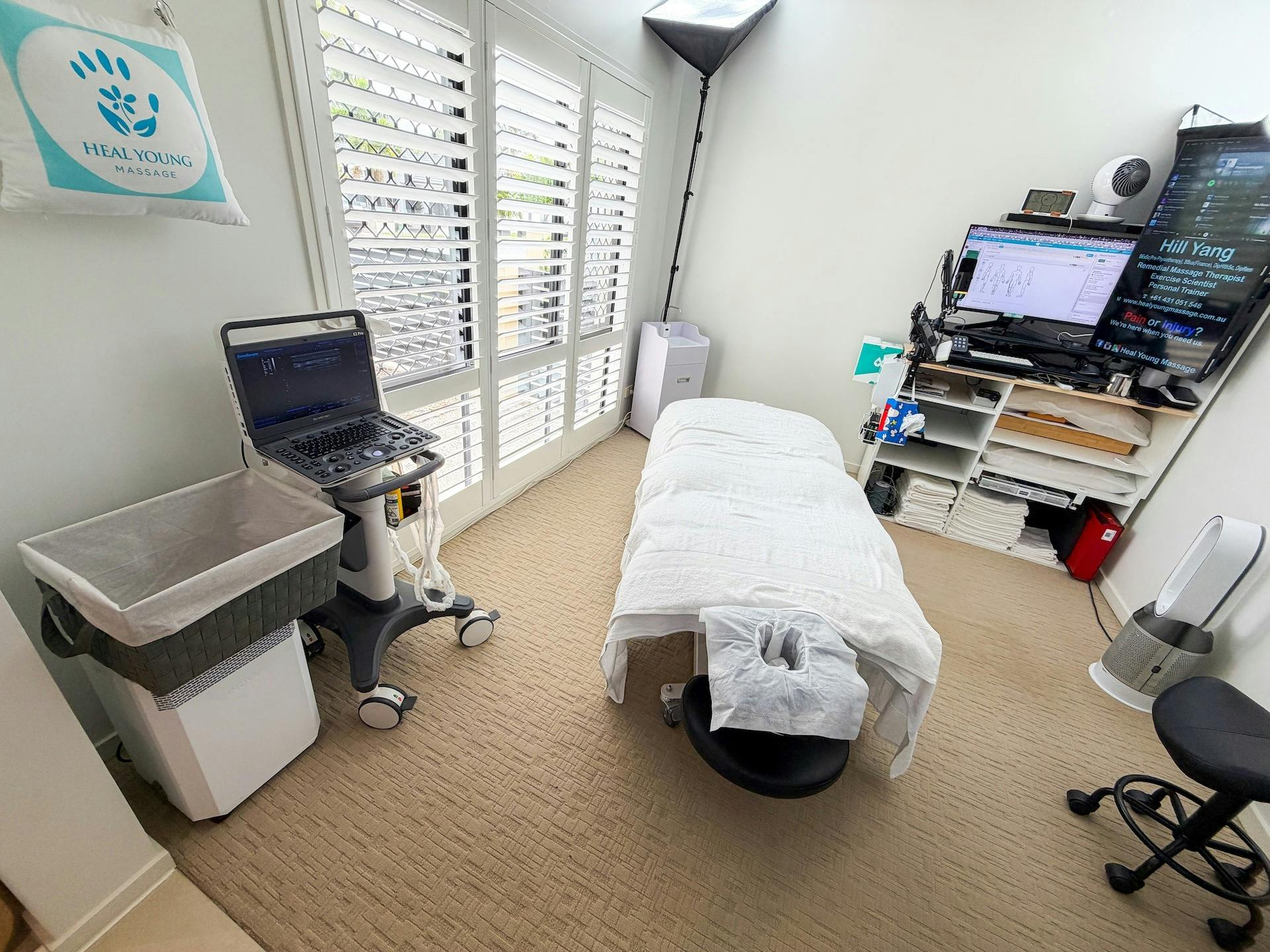 Heal Young Massage treatment room with massage table and diagnostic ultrasound on Gold Coast.