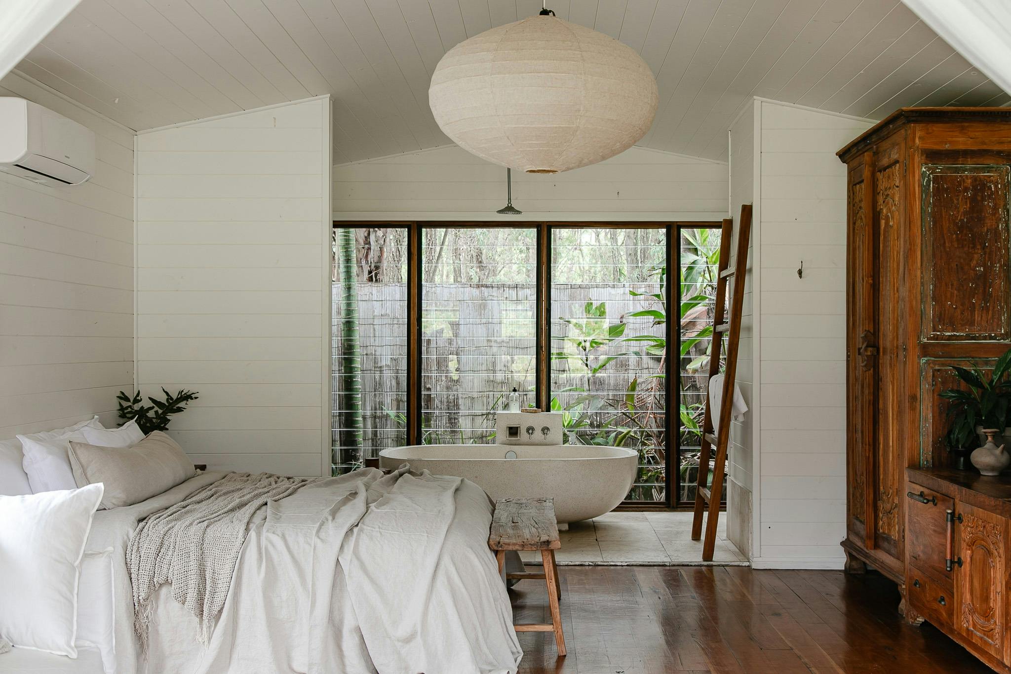 King bed with luxury linens and large stone bath