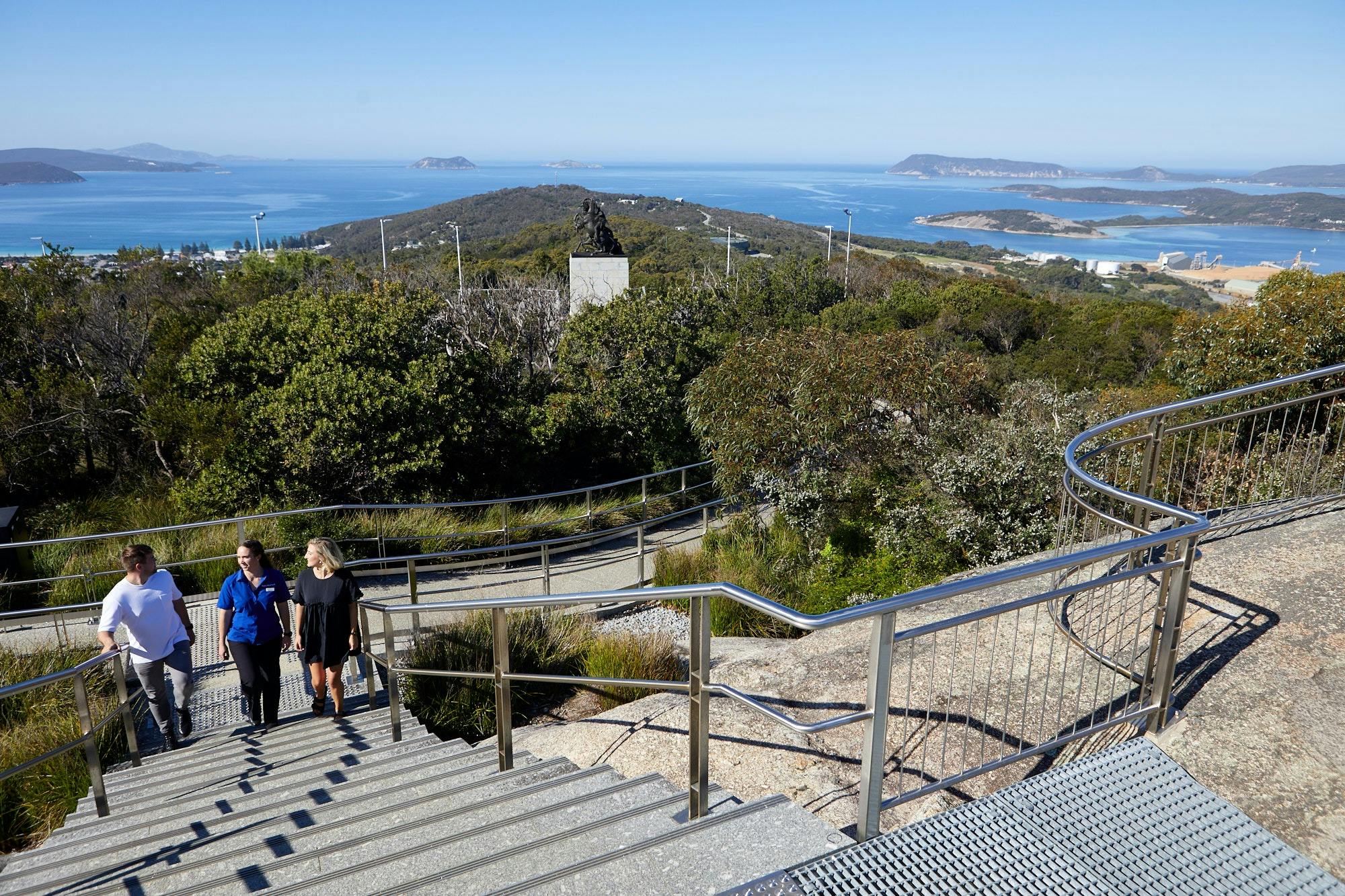 Busy Blue Bus Tours Guide walking with guests to Padre White Lookout with Desert Mounted Corps Memor