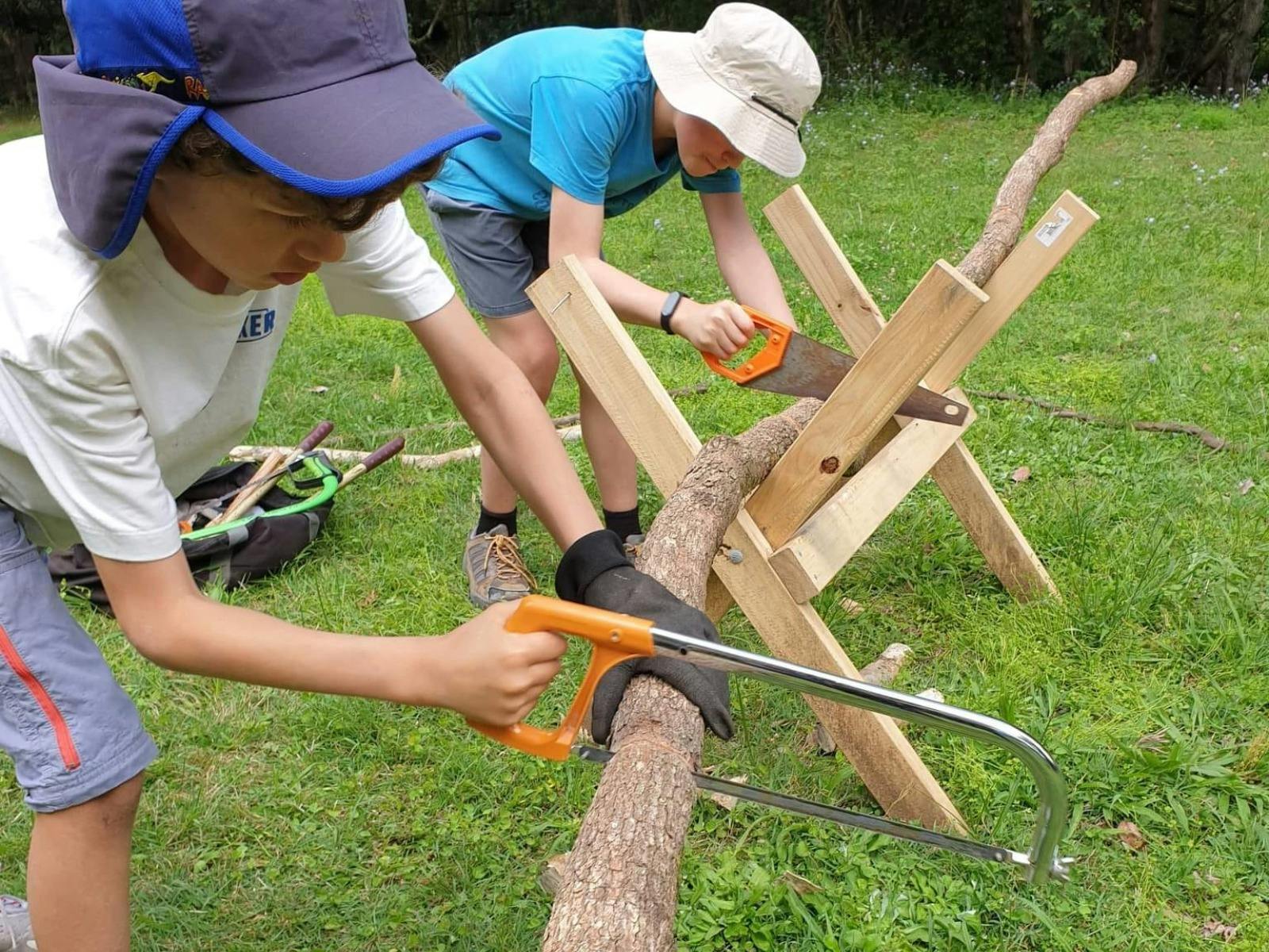 Children sawing wood at Birdwings Forest School Kids Holiday Nature Adventures Gold Coast Hinterland