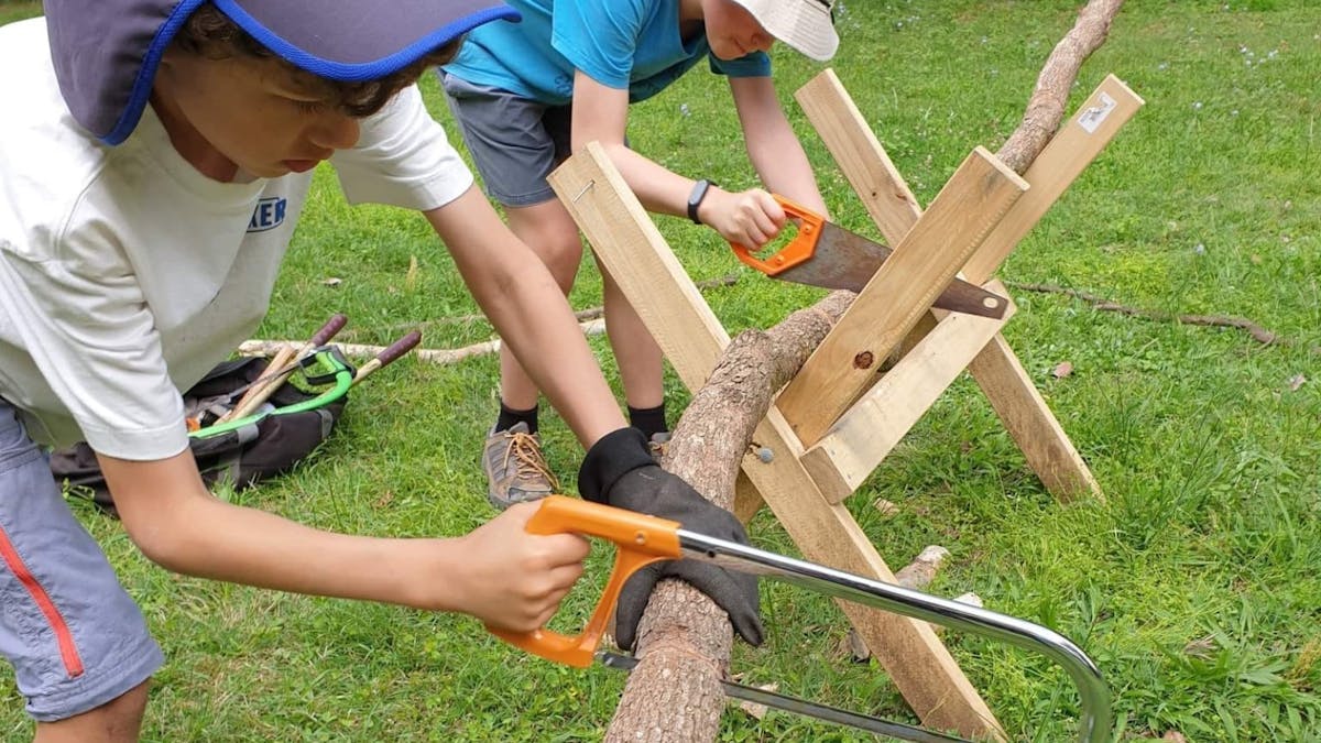 Children sawing wood at Birdwings Forest School Kids Holiday Nature Adventures Gold Coast Hinterland