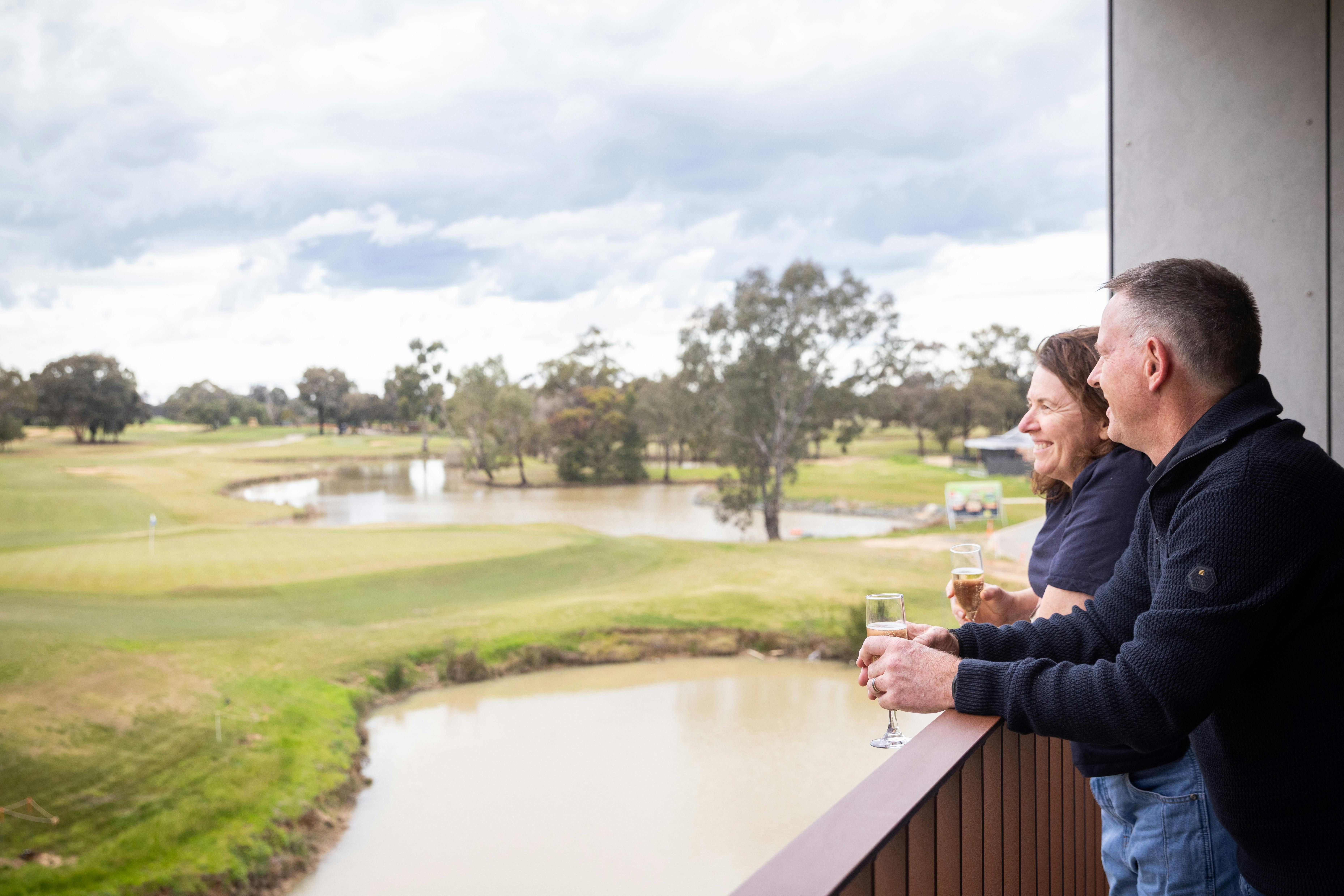 Couple enjoying the balcony of a  studio room overlooking the  golf course.