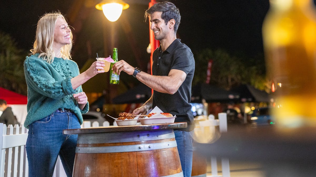 Couple cheers drinks at night market