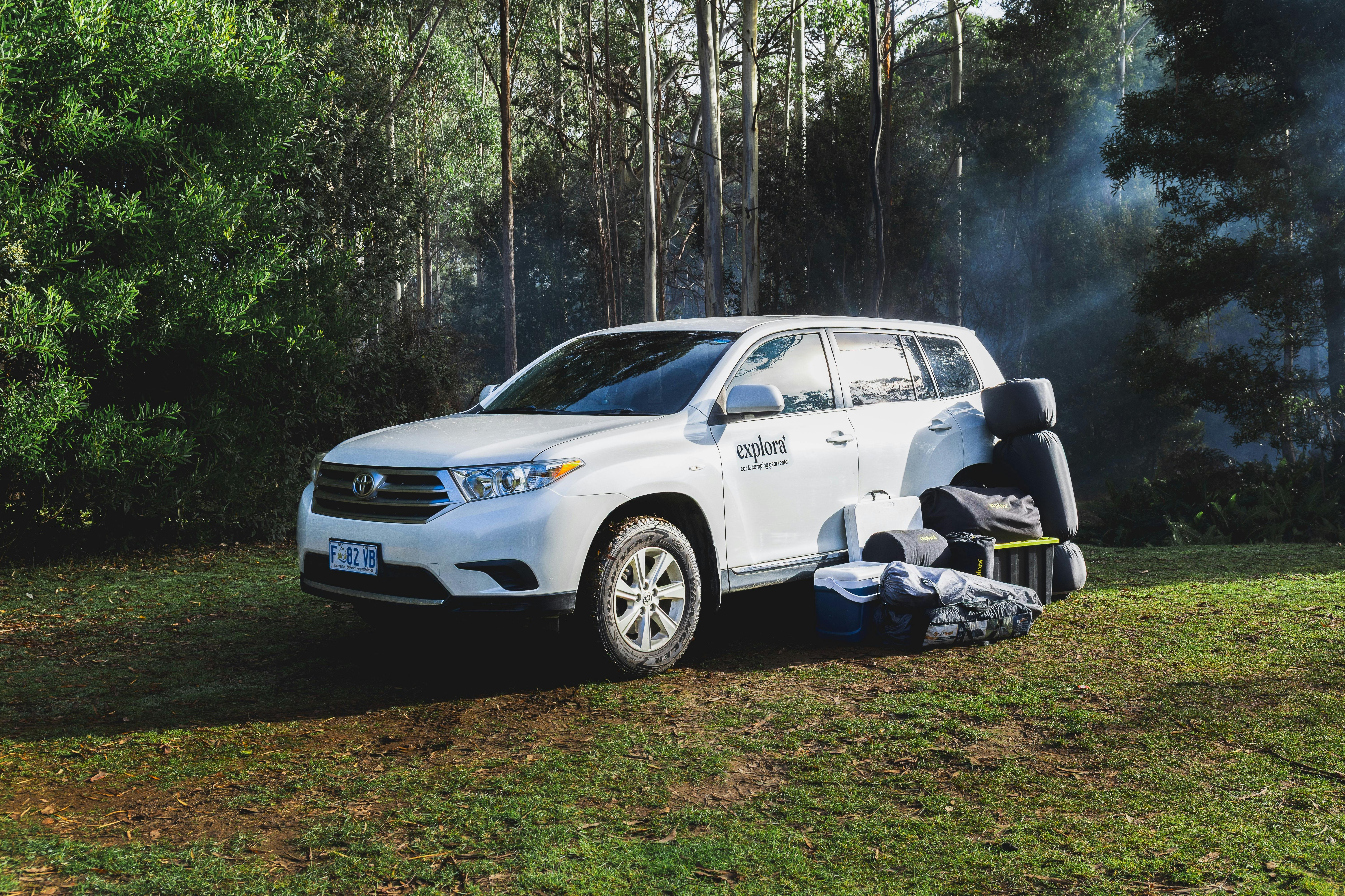 A car that has the camping gear next to it