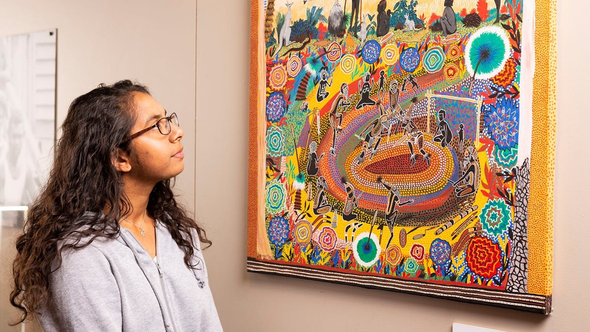 Young girl observes Vincent Serico painting in the Binangar Centre