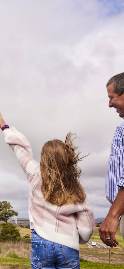 family pointing a large wind turbine