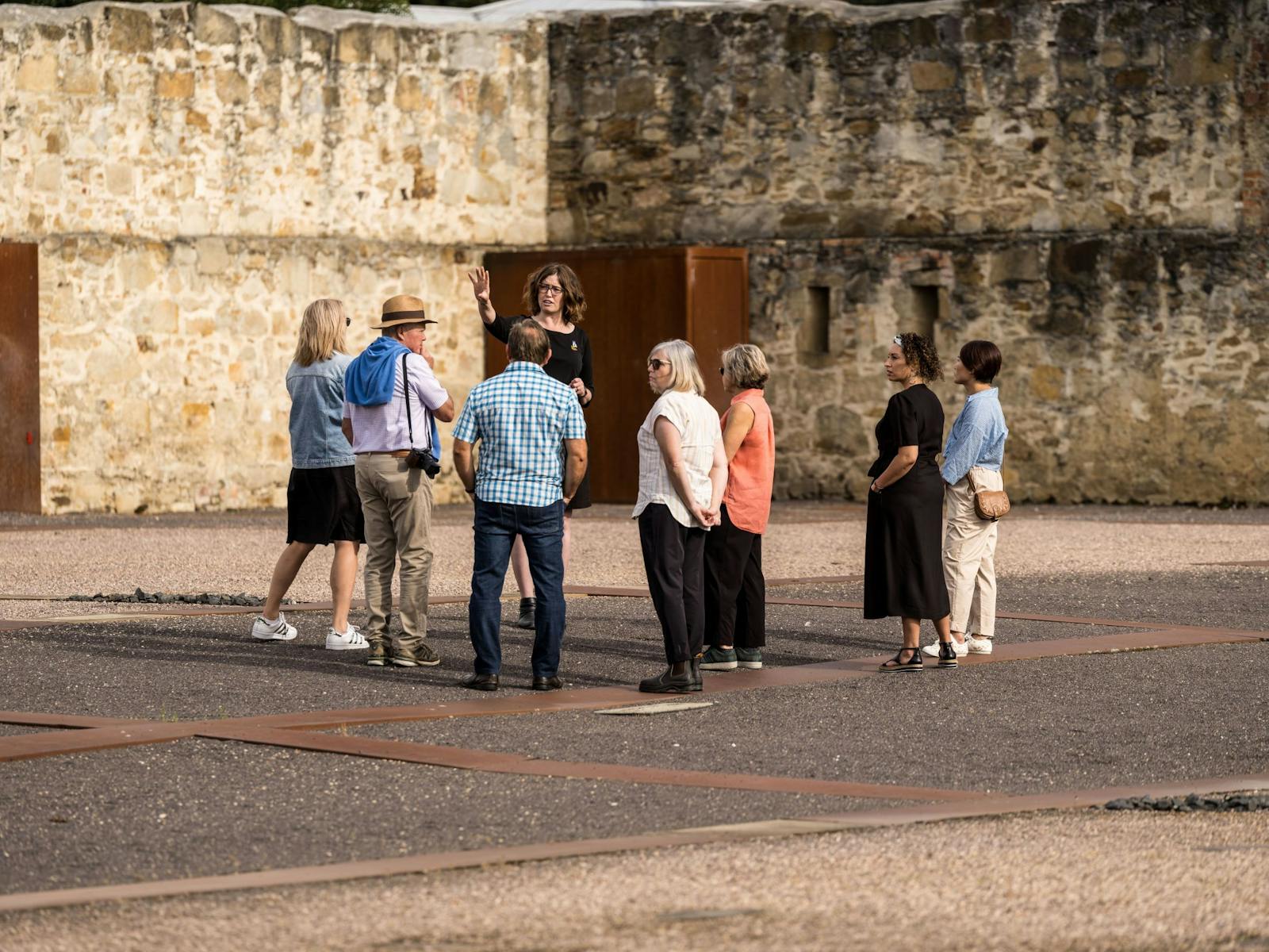 A group of visitor standing around the tour guide for a Convict Women's Tour