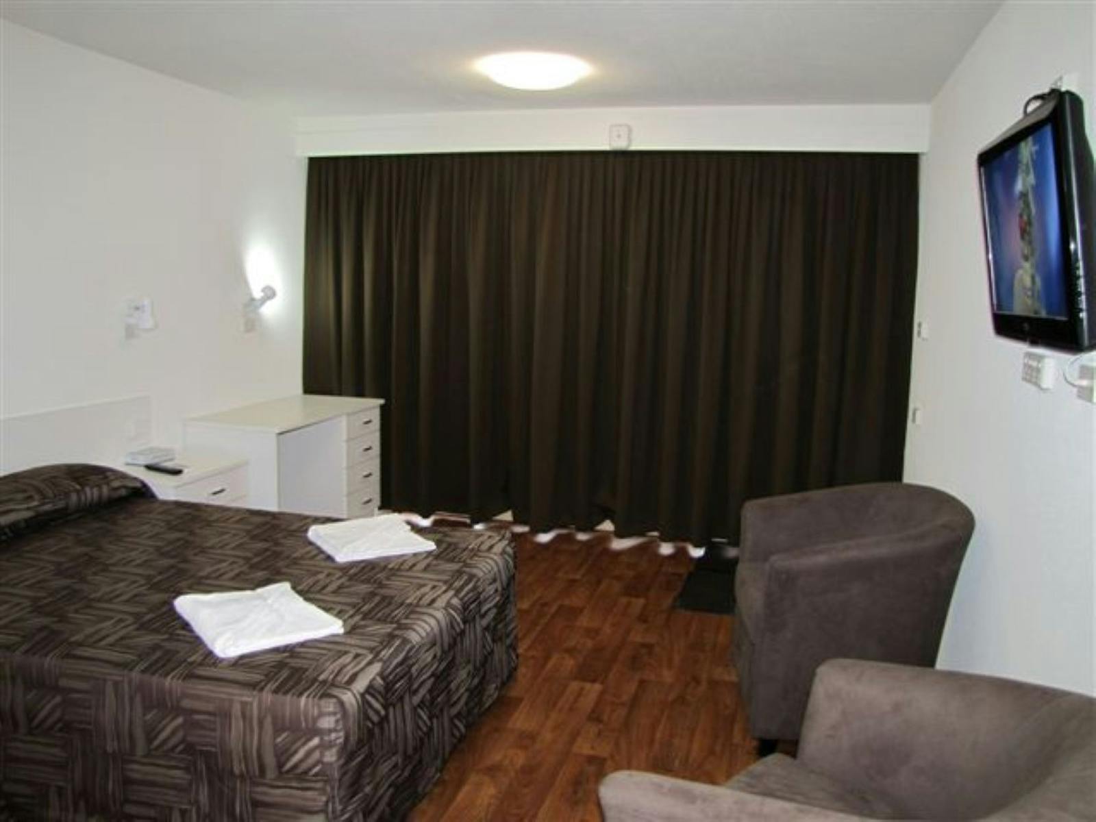 Double bed with tv and lounge chairs