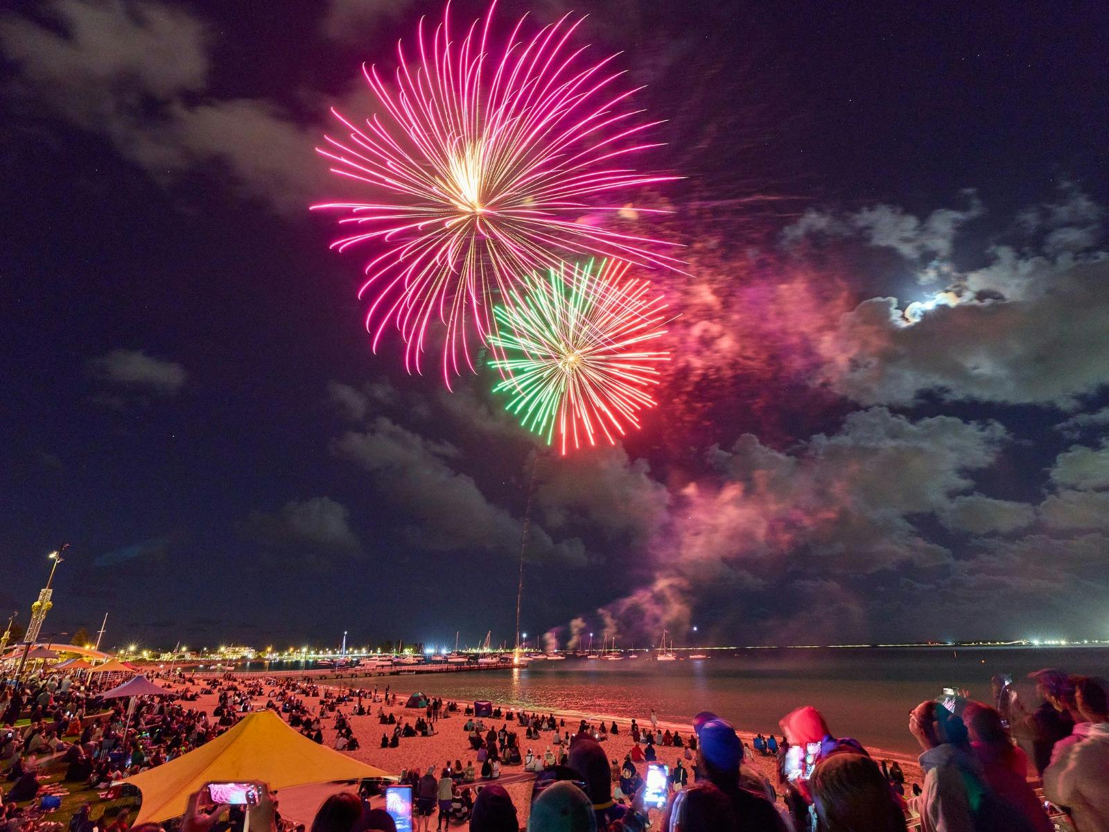 Colourful fireworks display over the ocean