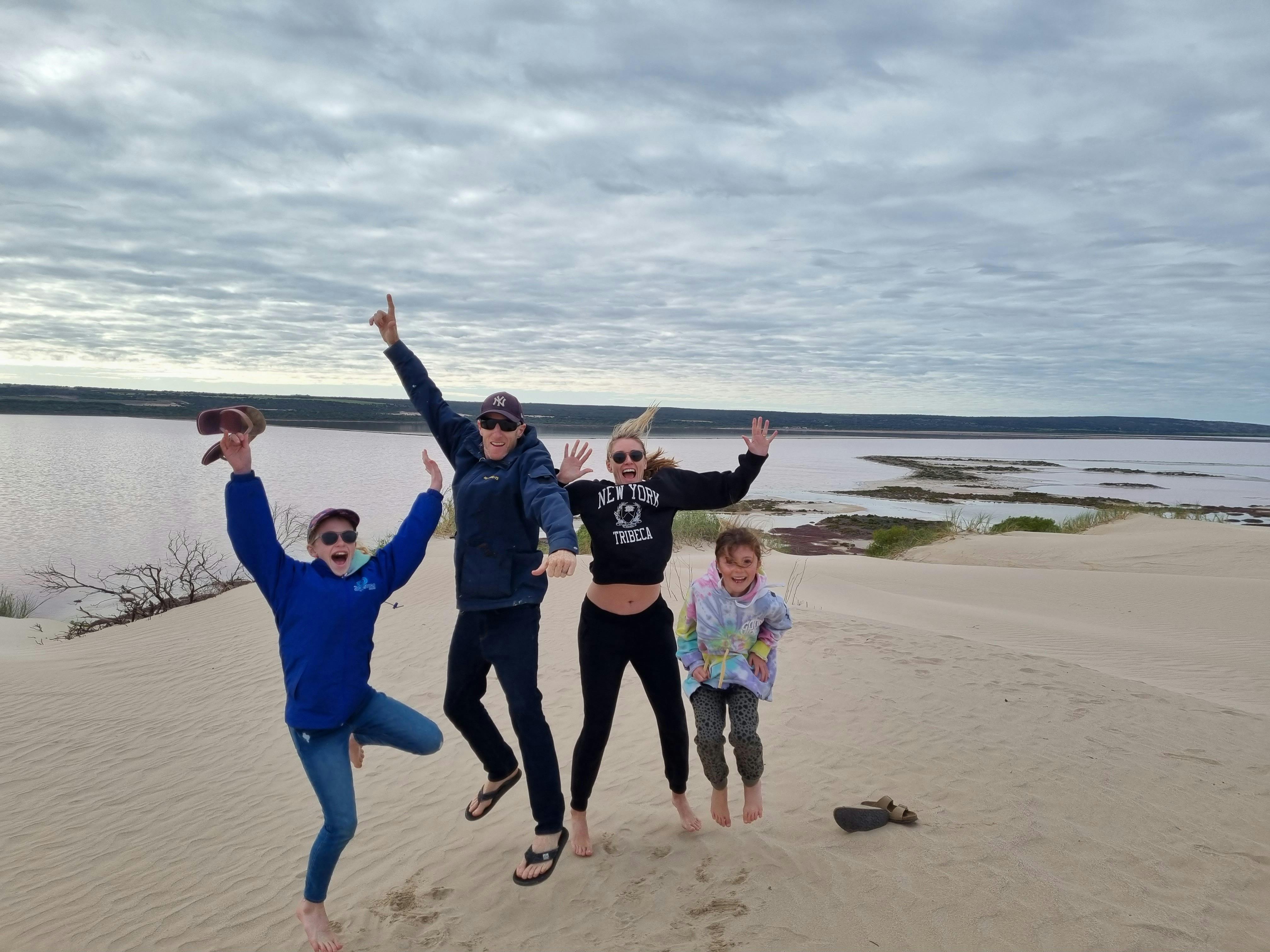Family jumping on the dunes on tour