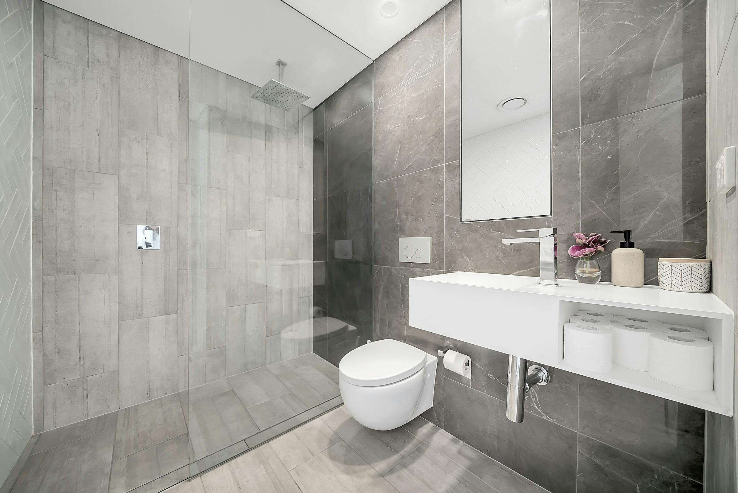 Sleek modern bathroom with glass shower and minimalist decor.