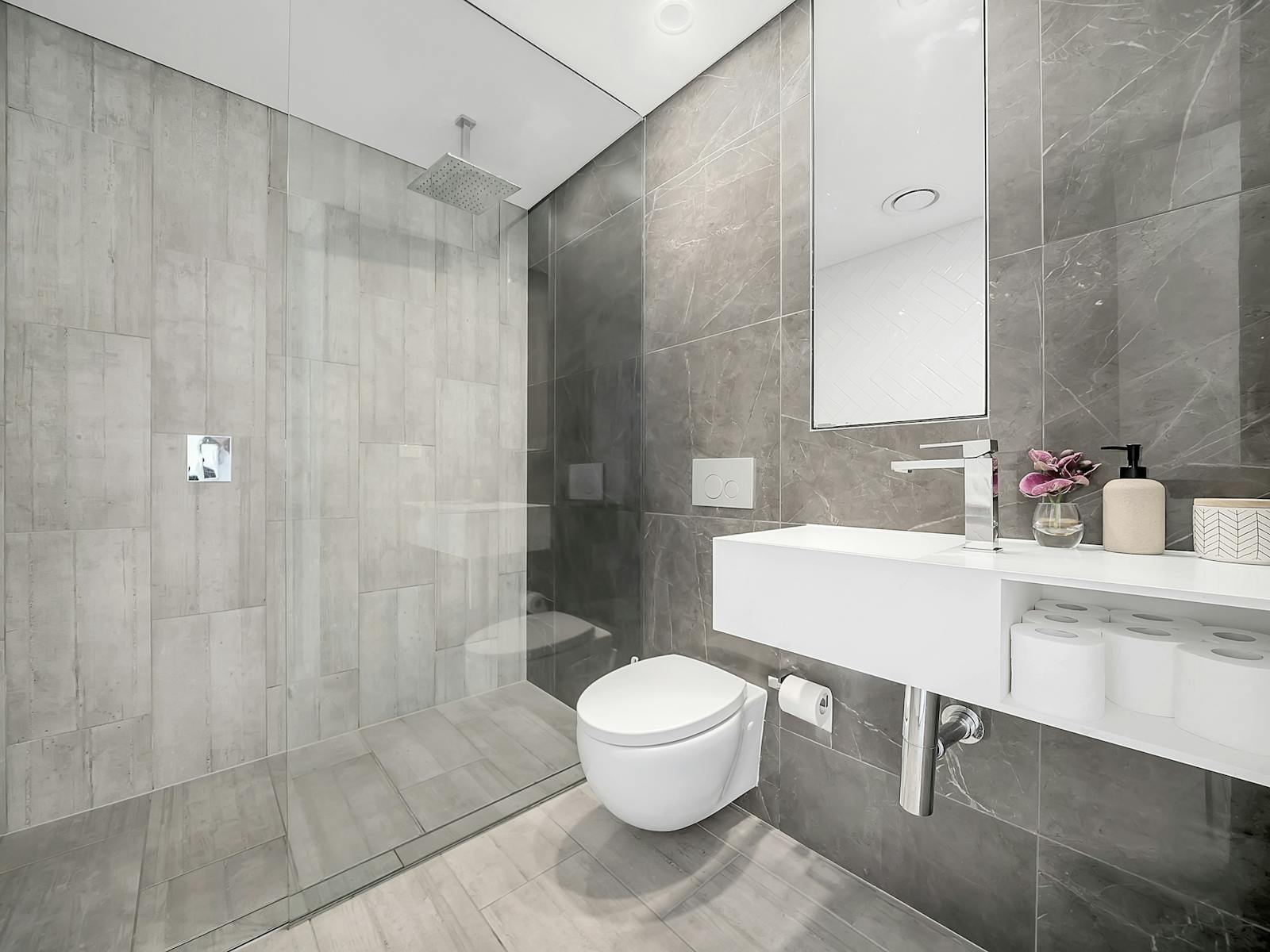 Sleek modern bathroom with glass shower and minimalist decor.