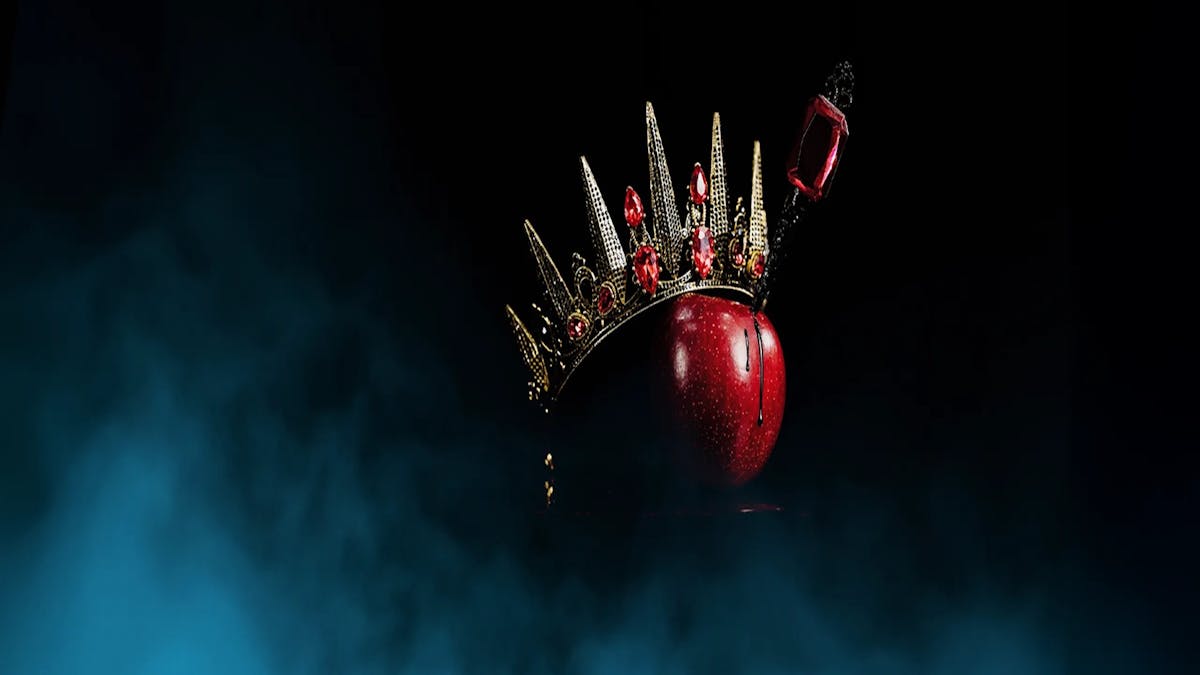 A red apple with a crown and dagger in it. Ballet Theatre Queensland Snow White.