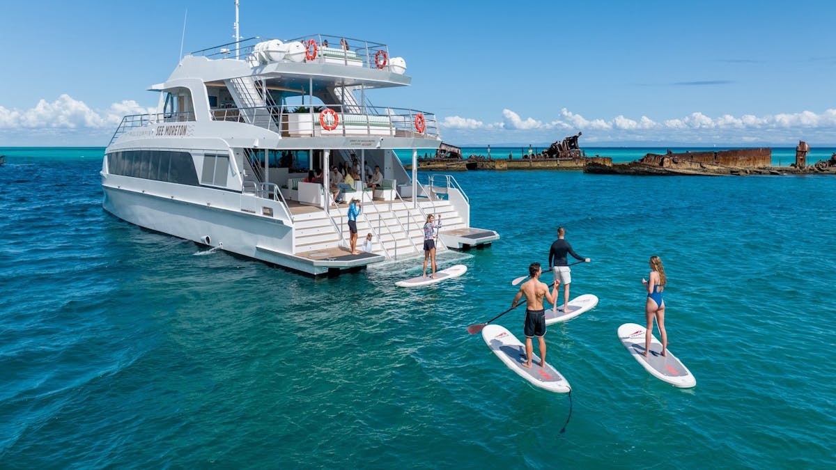 Stand up paddleboarders exploring the Tangalooma Wrecks