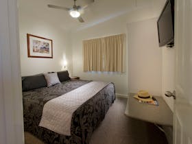 comfortable king sized bed in the main bedroom with TV and fan