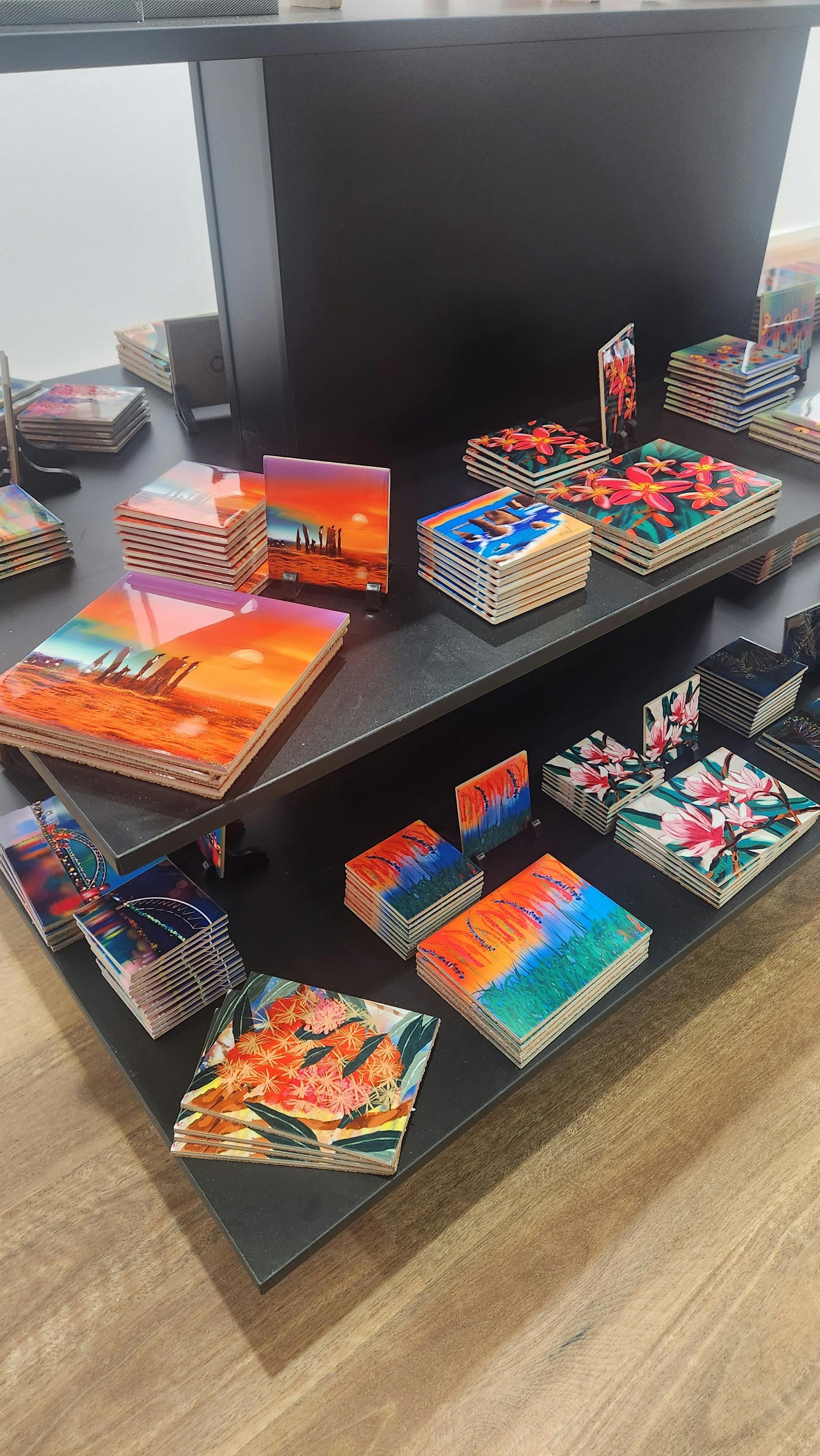 Colourful coasters and trivets in square and rectangular shape on a black display table