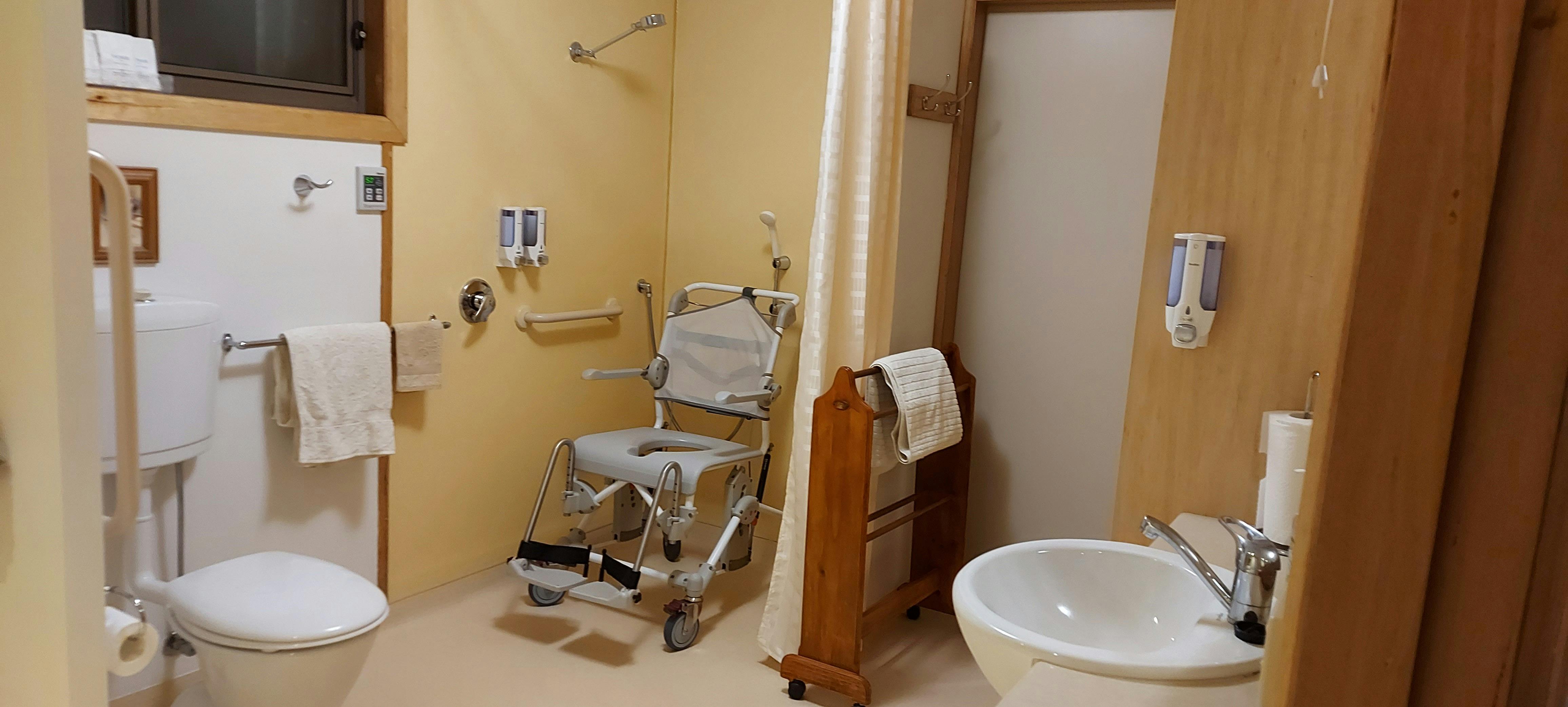 Accessible step less shower with tilt commode shower chair available on request.