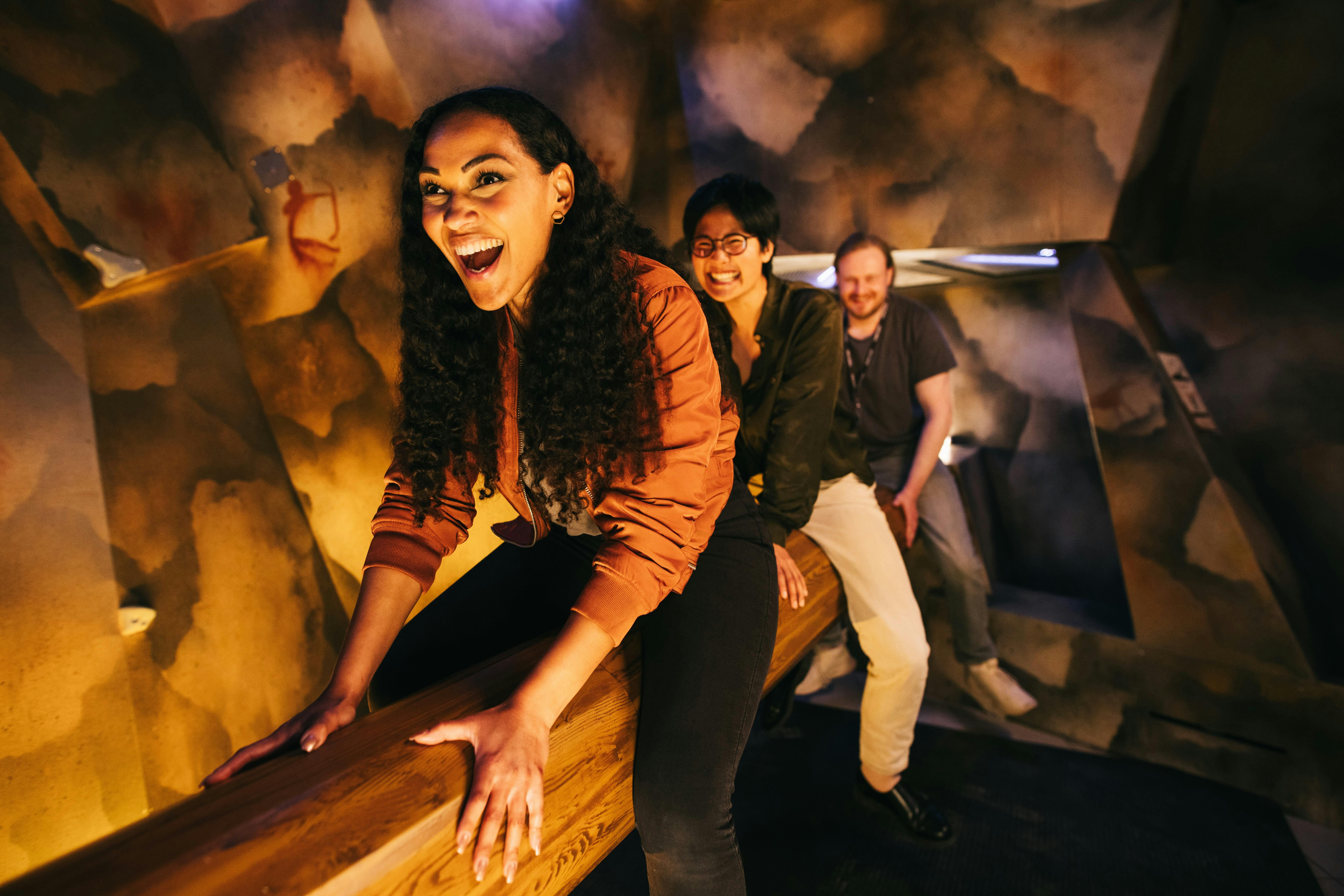 Friends climbing across a log to complete a challenge