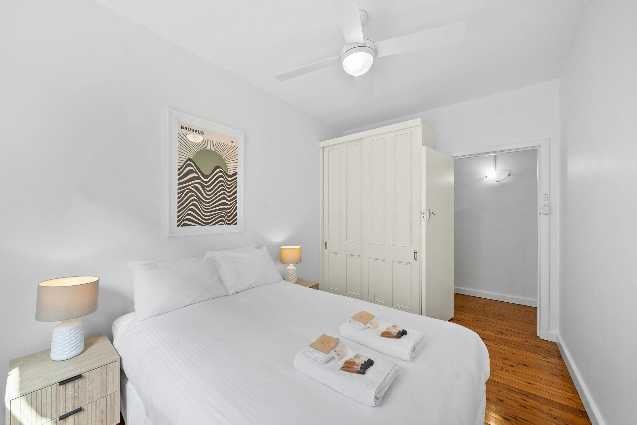 明亮、簡約的臥室，採用白色色調和現代家具。