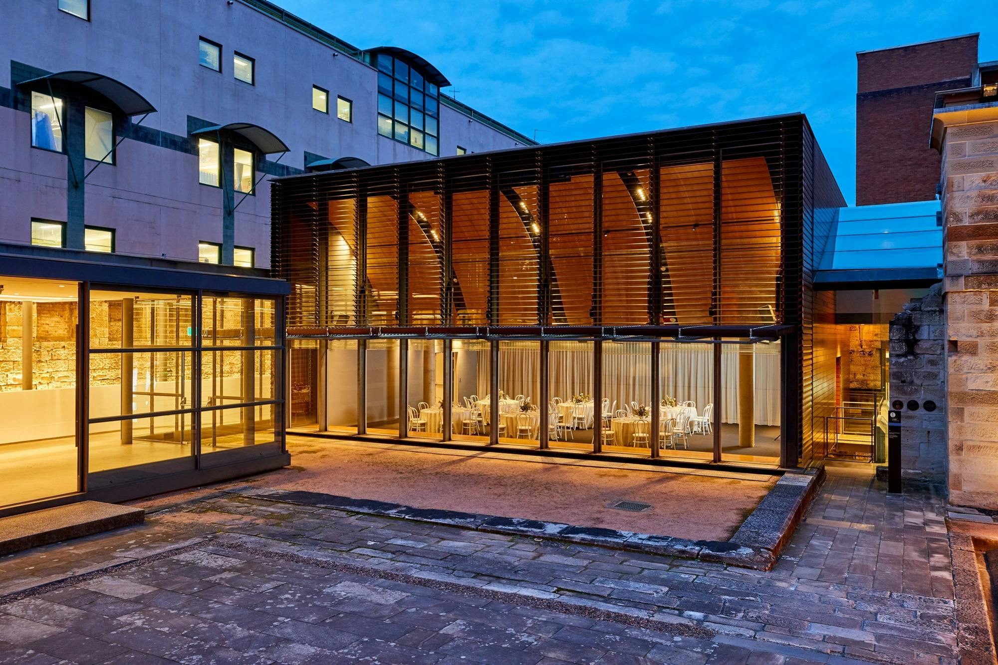 Modern extension of historic building lit at evening