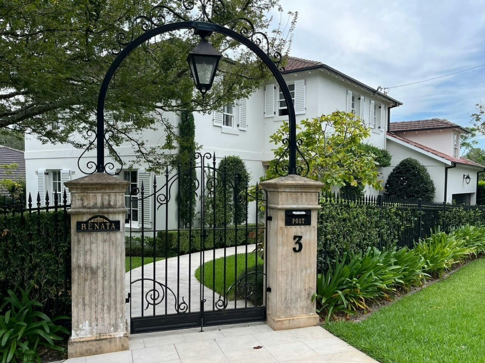 A name plaque 'Renata' is attached to grand gates out the front of a stunning shuttered building.