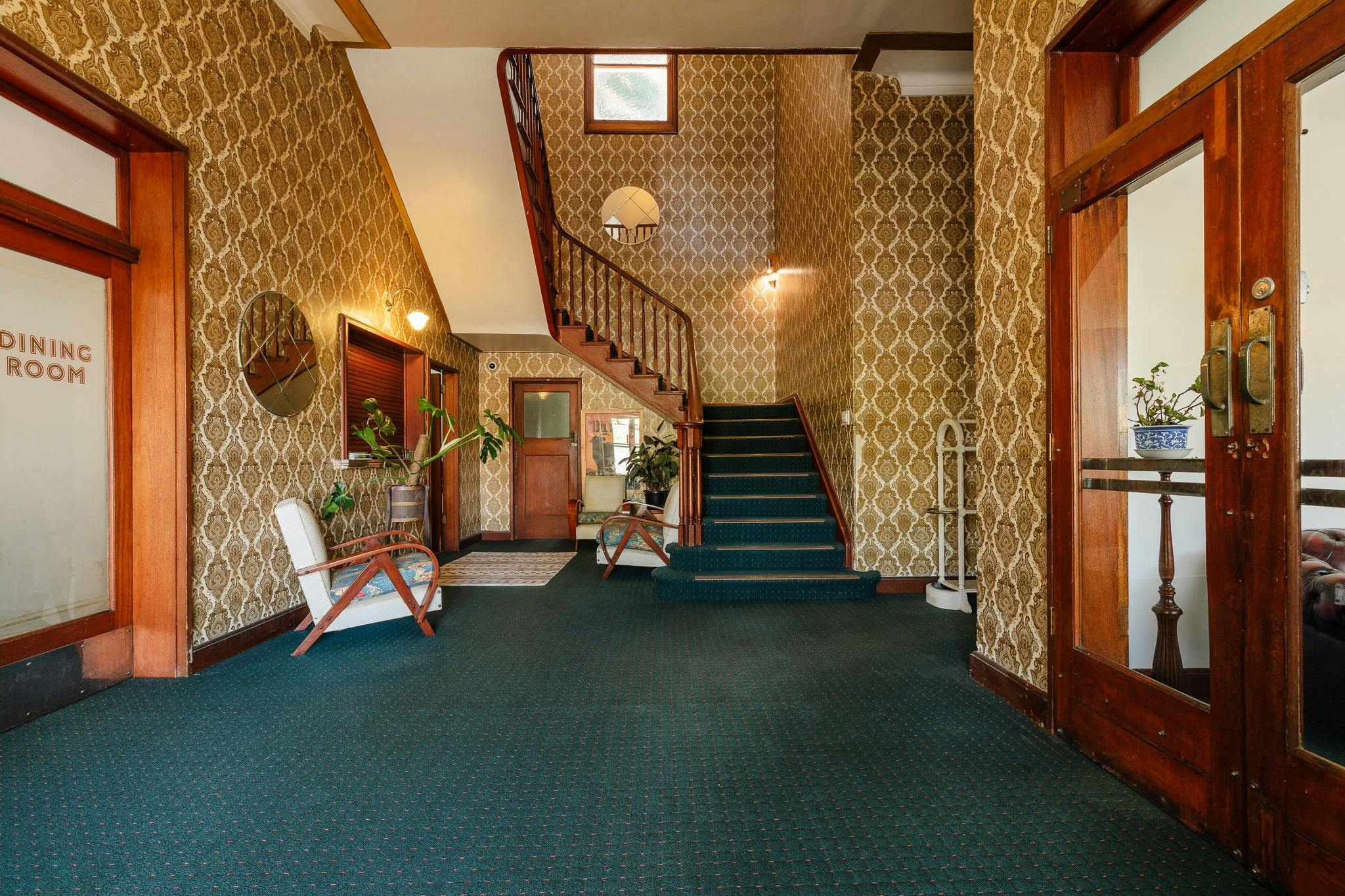 Entrance hall green carpet tall staircase gold wallpaper
