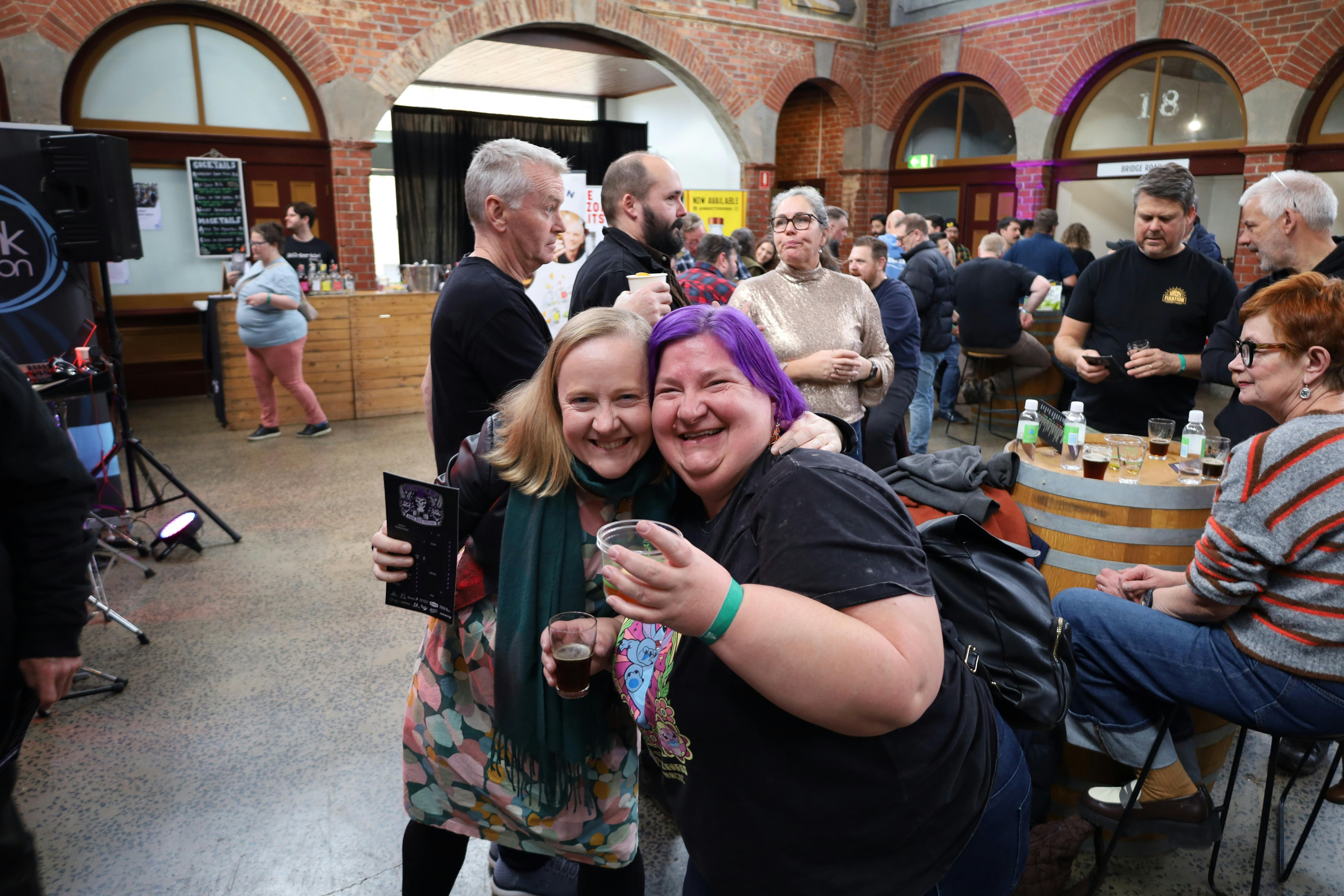 Attednees smiling for the camera with a beer in hand