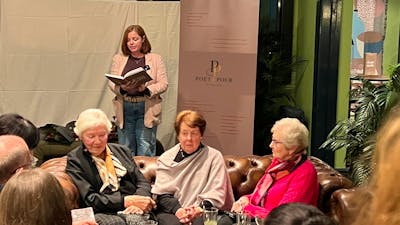 Audience listening to a poet speaking from a text