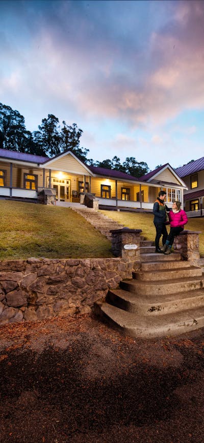 Couple standing on steps in front of caves house