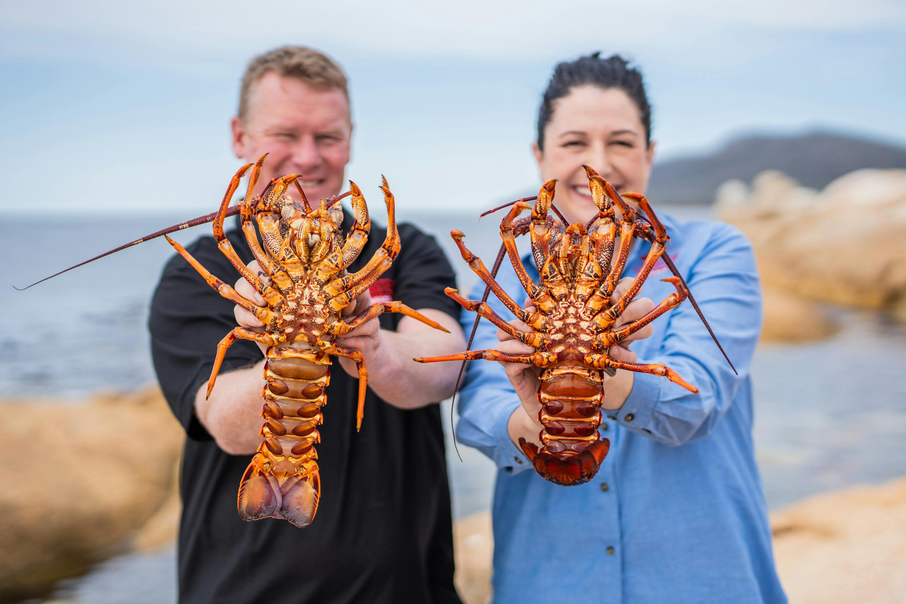 Photo of Lobster Shack Tasmania owners, Marcus and Sara Walkem holding southern rock lobsters