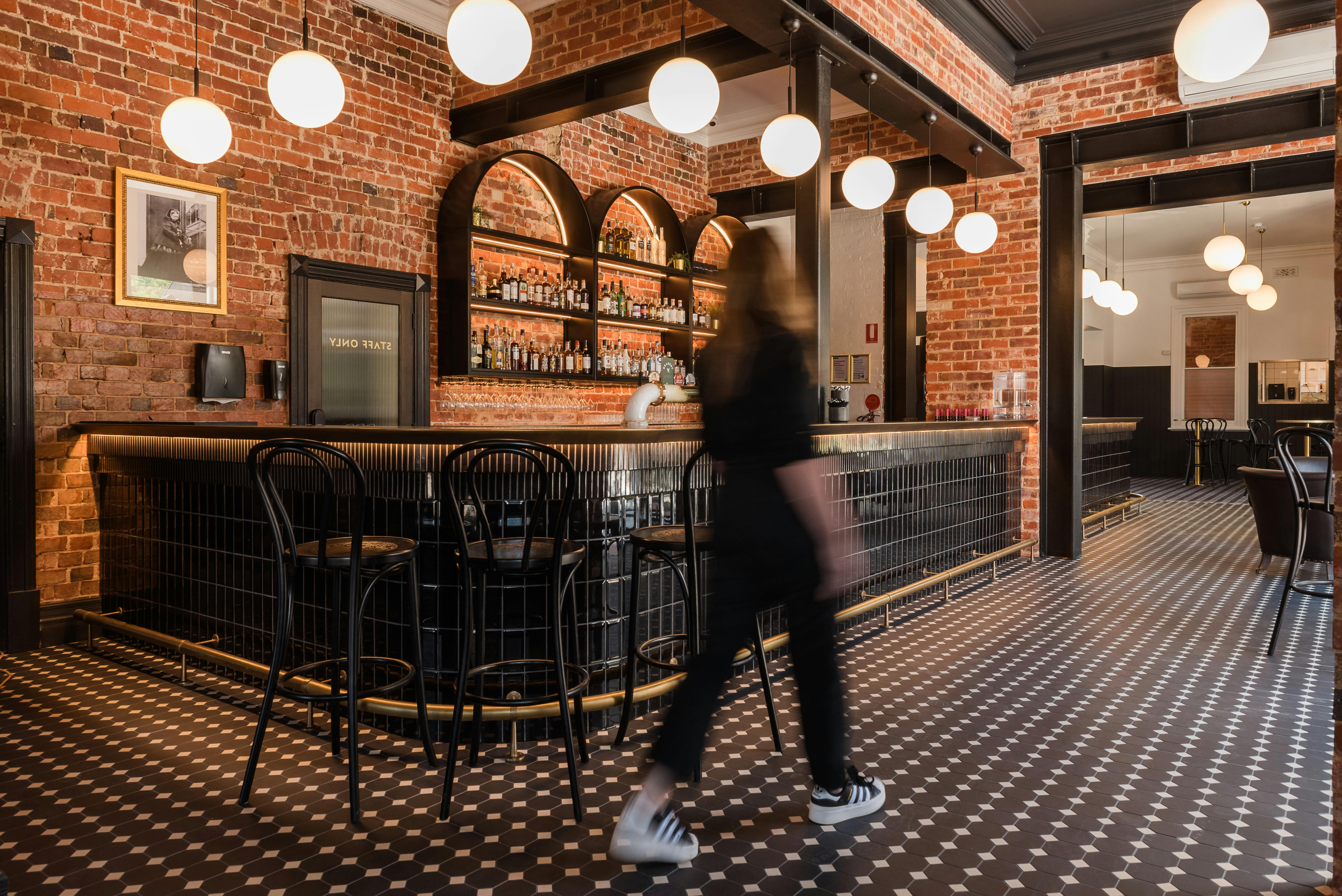 一位女士走過拉瑟格倫維多利亞酒店的酒吧