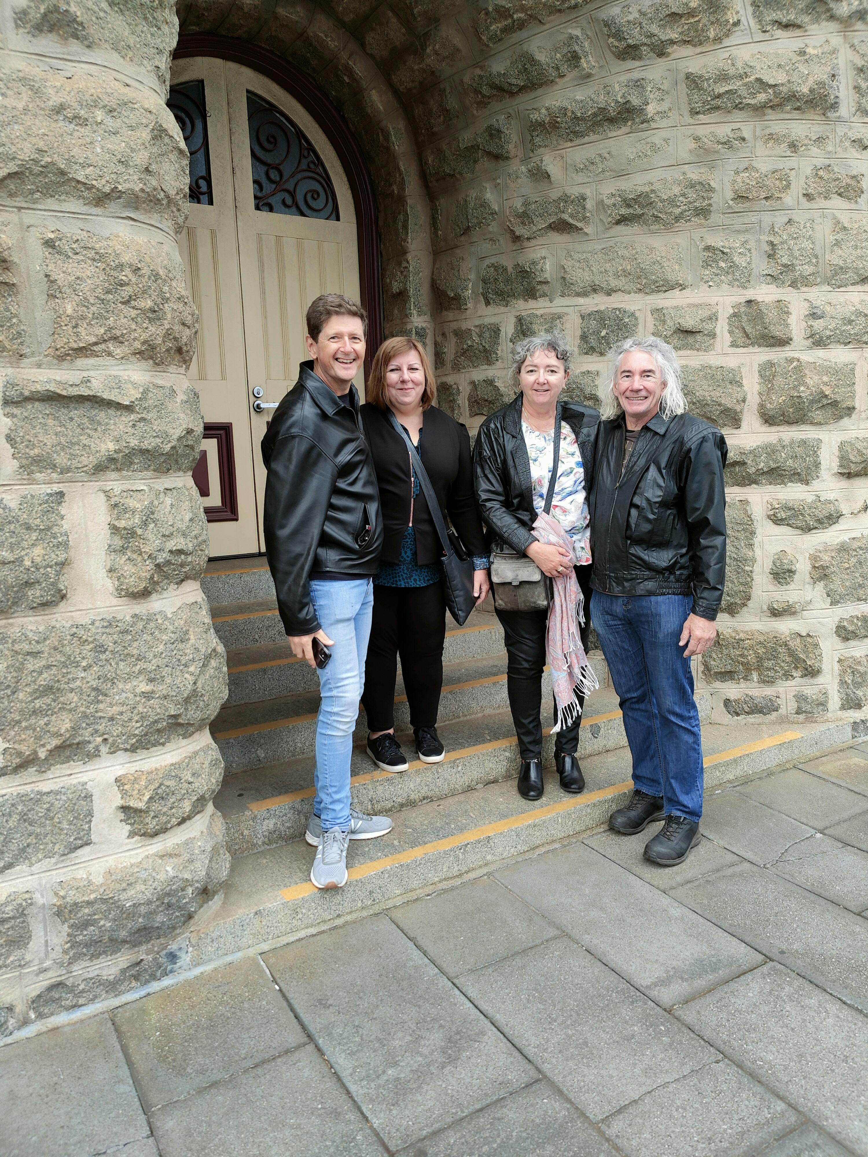 group of four people in alcove entry of stone building