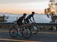 Two road cyclists riding up Mount Buffalo at sunrise
