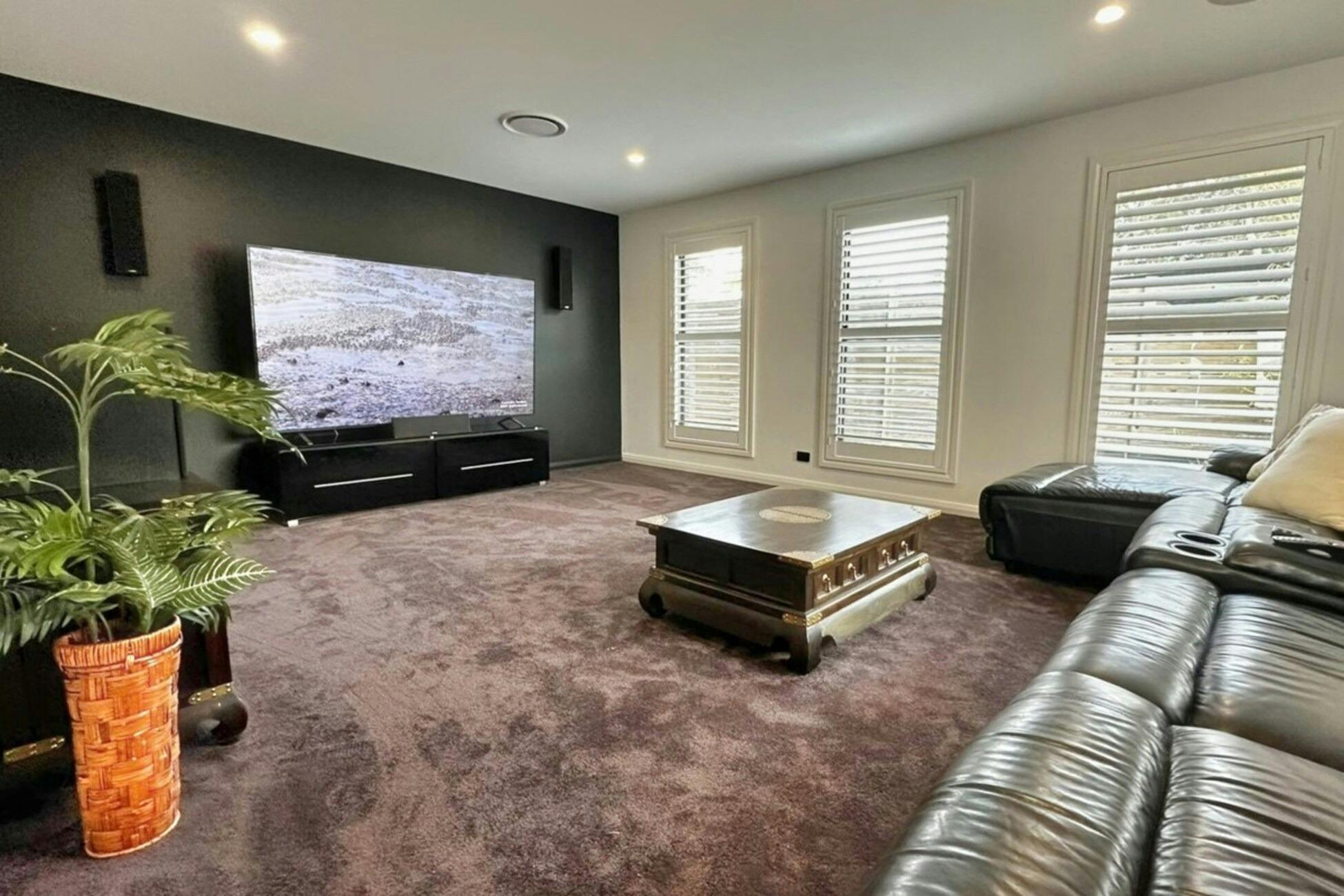 Media room with comfortable seating and large TV