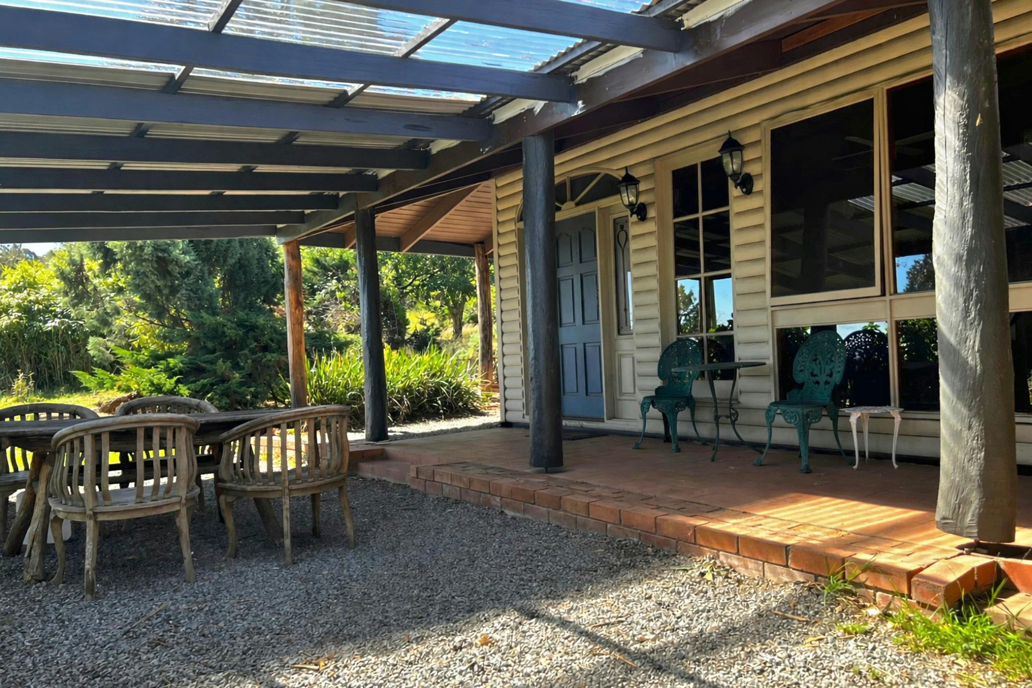 Wollemi Cottage at Widden Brook Farm showing the covered veranda, blue front door, outdoor seating