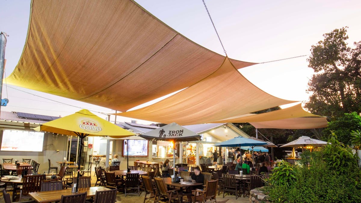 Dingo Beach Pub beer garden and outdoor dining area at dusk with relaxed seaside atmosphere.