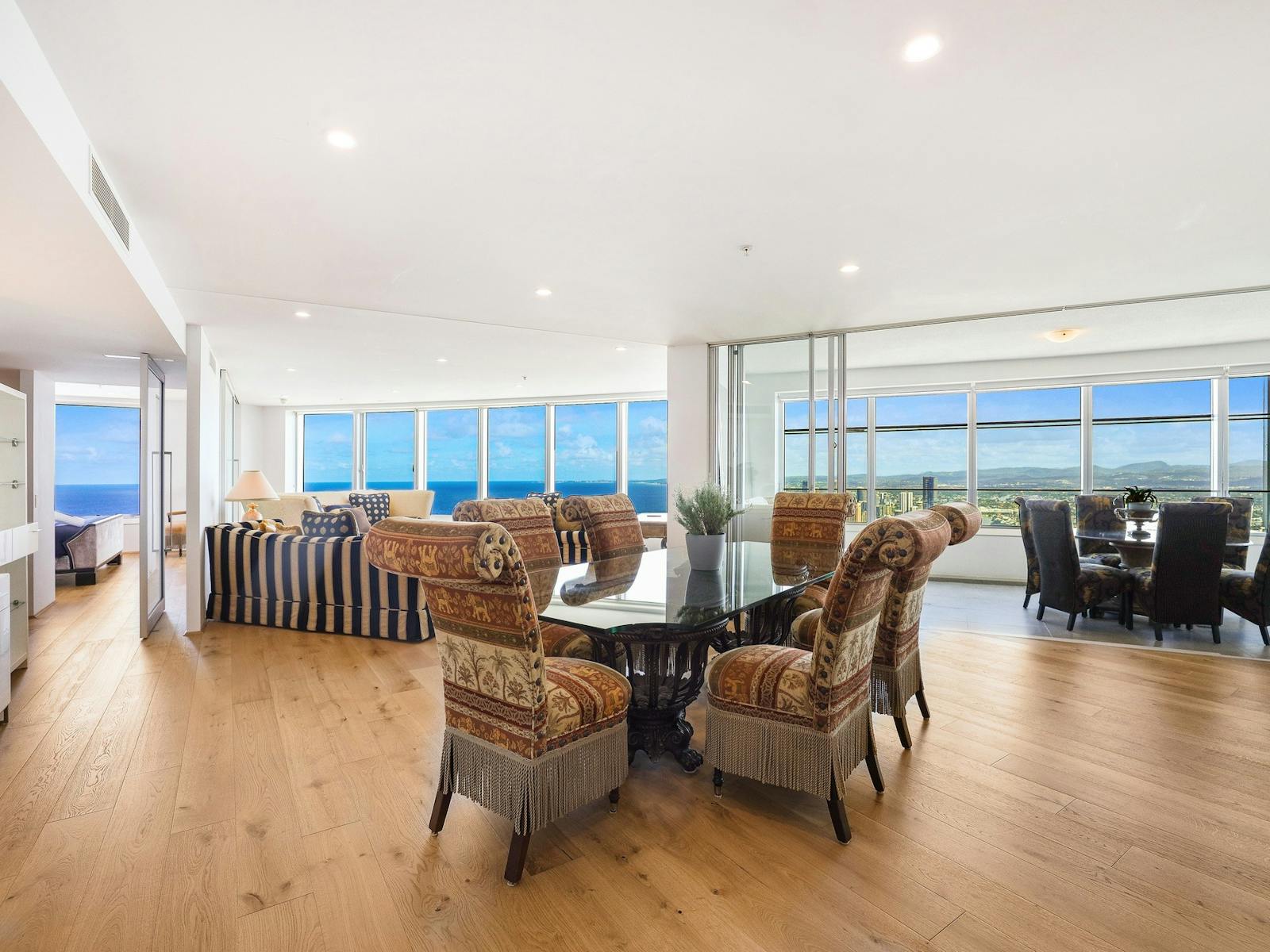 Open plan living - dining table indoor and outdoor on enclosed balcony - Gold Coast Holidays - Q1 Open plan living - dining table indoor and outdoor on enclosed balcony - Gold Coast Holidays - Q1