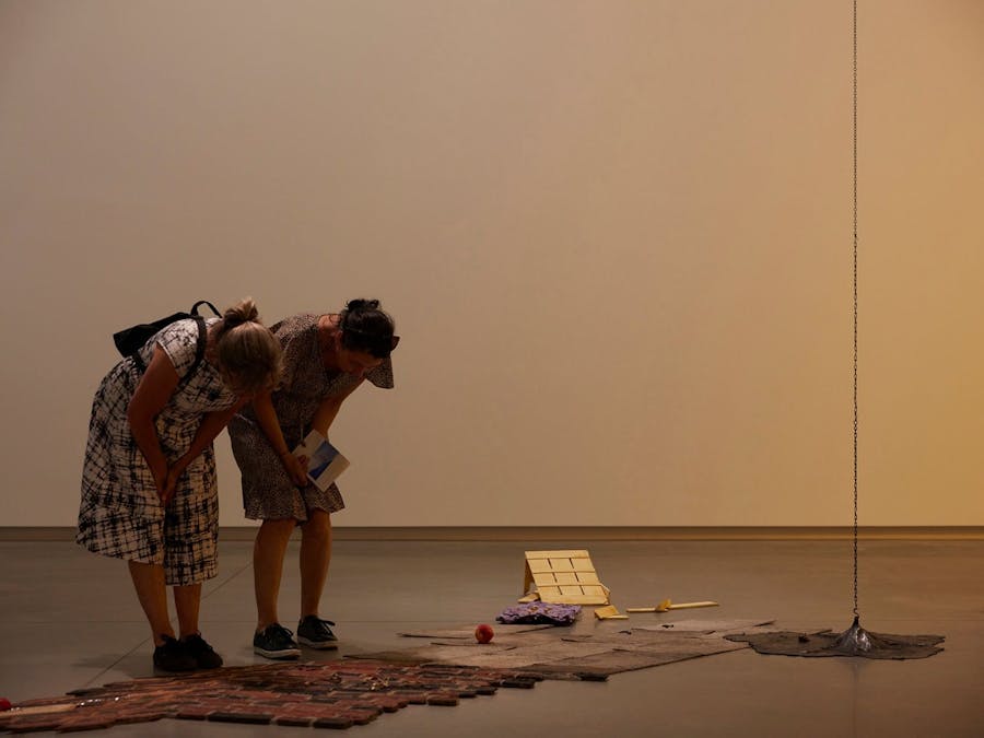 Two visitors examining a floor artwork