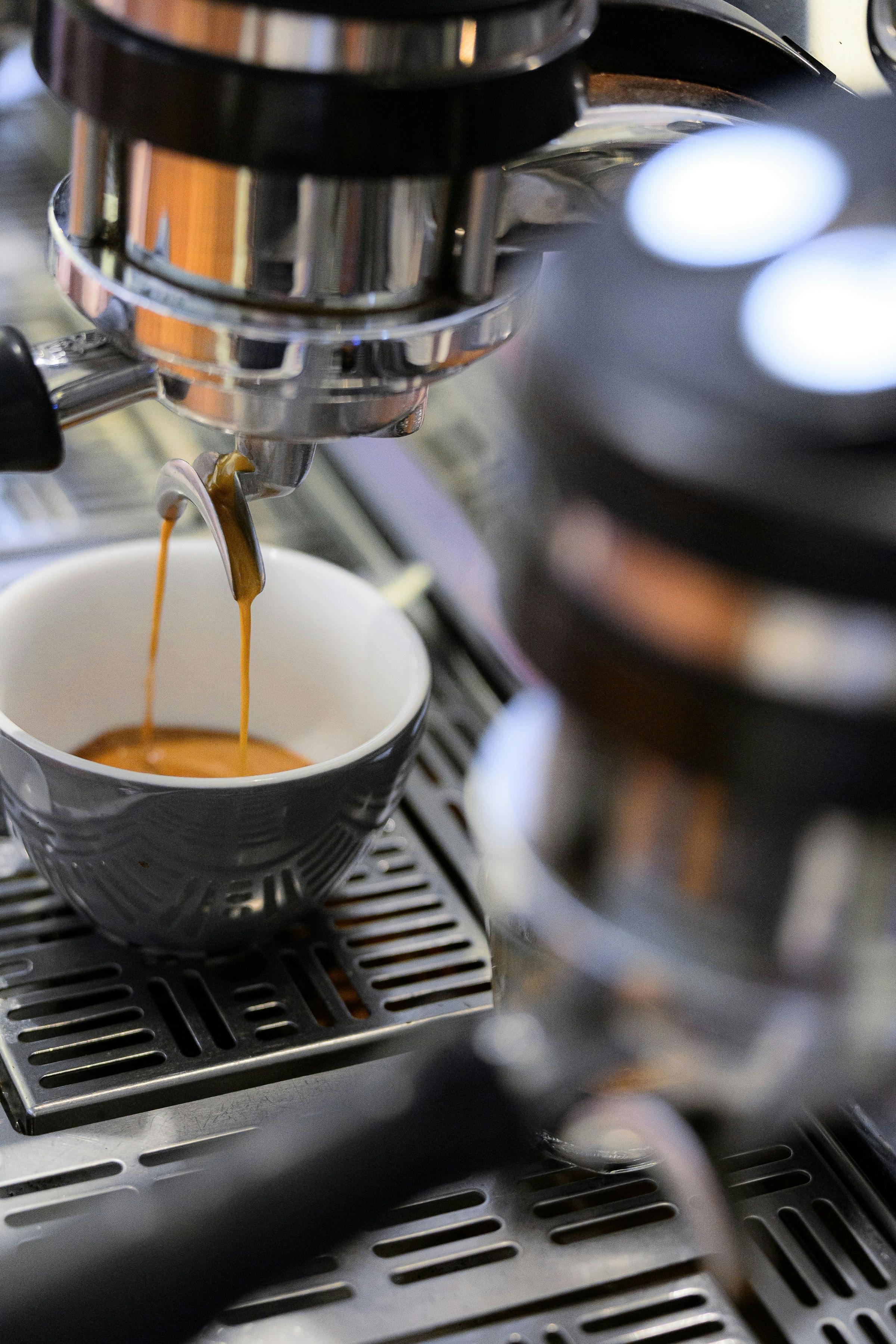 Espresso pouring into grey cup on la marzocco espresso machine.
