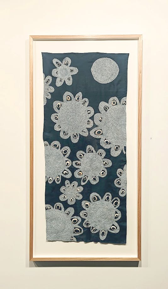 Blue textile with white embroidered flowers and shells