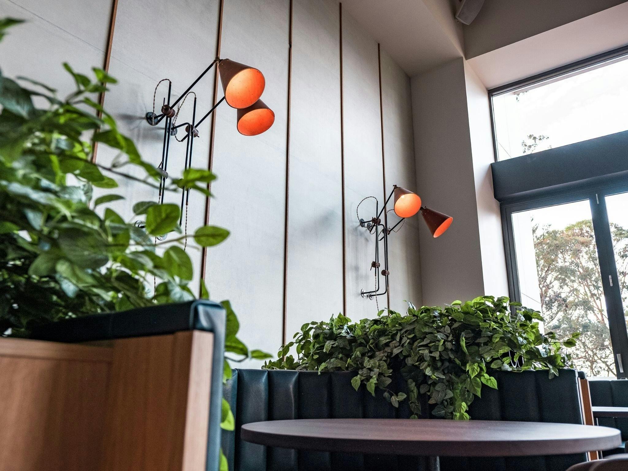 Interior shots of blue leather booths with greenery between at Rick Stein at Bannisters